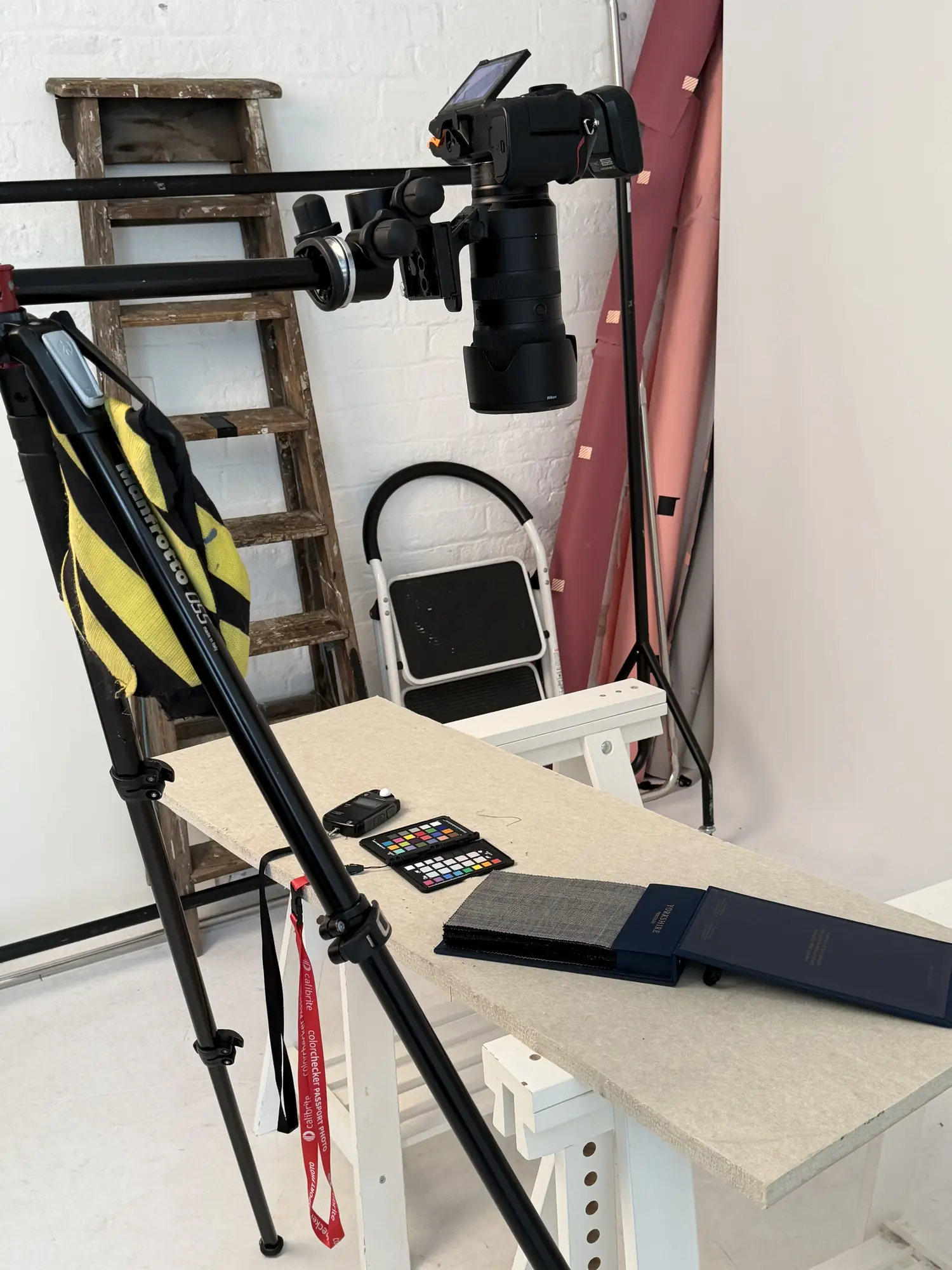 Overhead tethered camera rig above fabric swatches and a colour checker on a workbench at Dock Street Studio, Leeds