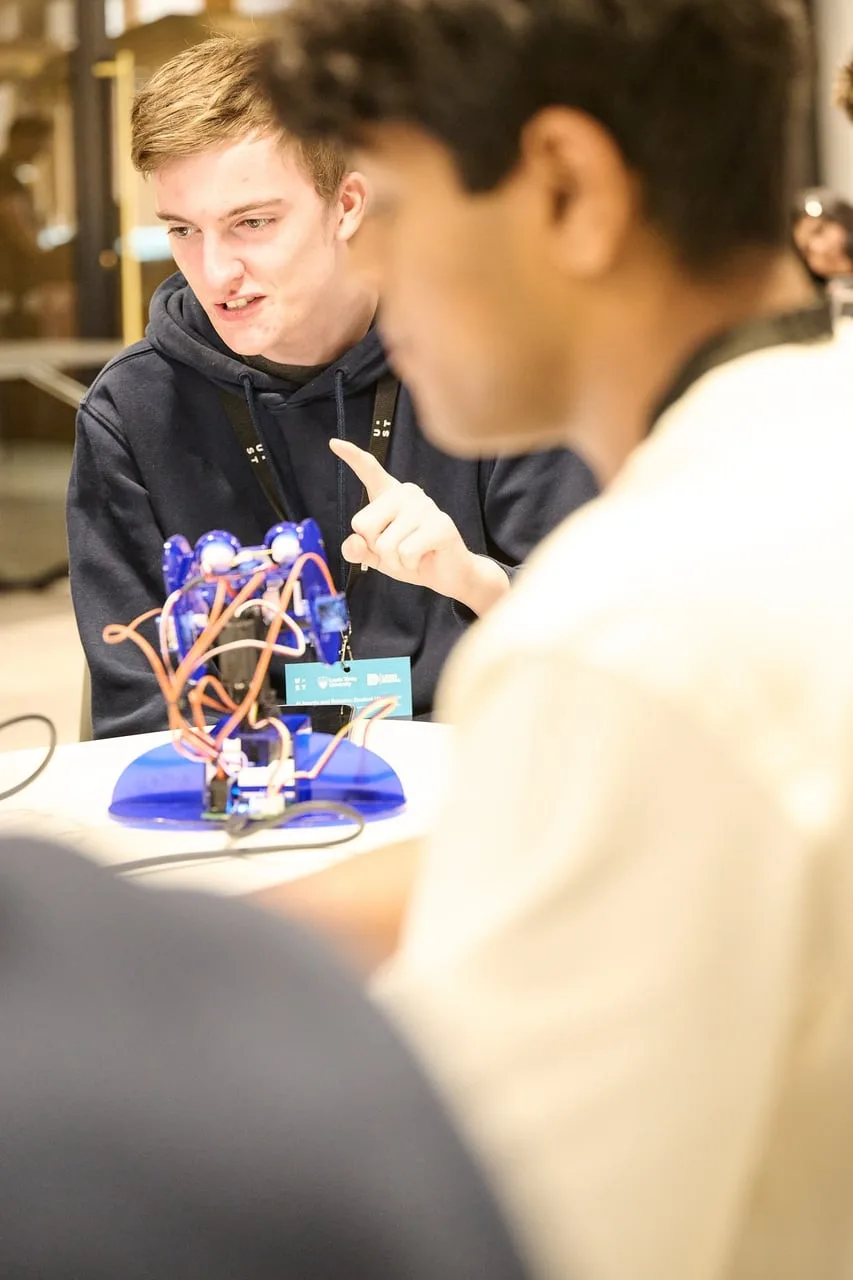 Close-up of a blue student-built robot at the AI Agents and Robotics Student Hackathon, hosted by UST for Leeds Digital Festival — event photography by Dock Street Studio, Leeds