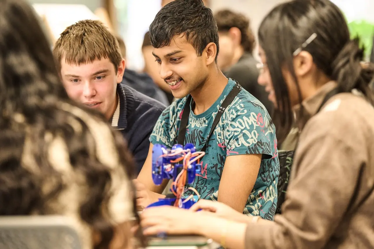 Students laughing as they test a robot at the AI Agents and Robotics Student Hackathon, hosted by UST for Leeds Digital Festival — event photography by Dock Street Studio, Leeds