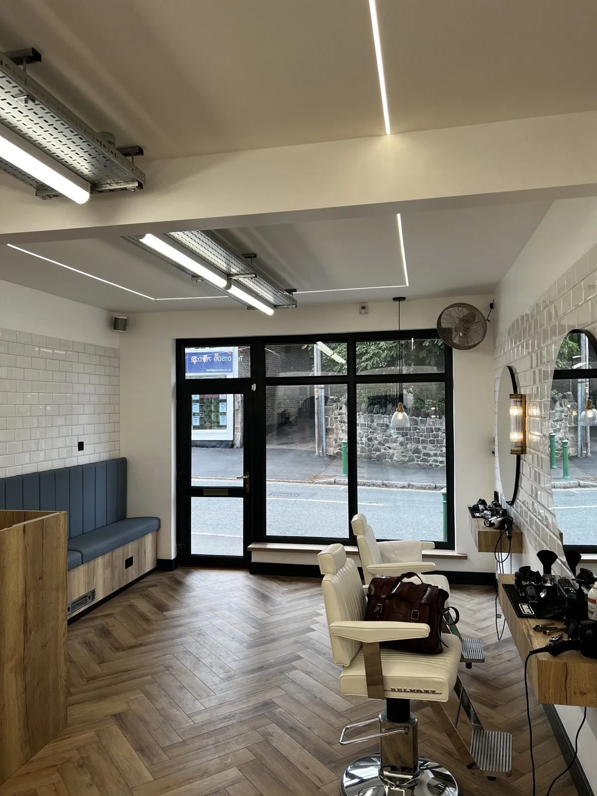 Inside Barrow Barber Co, with LED strip lighting and lights on exposed cable tray