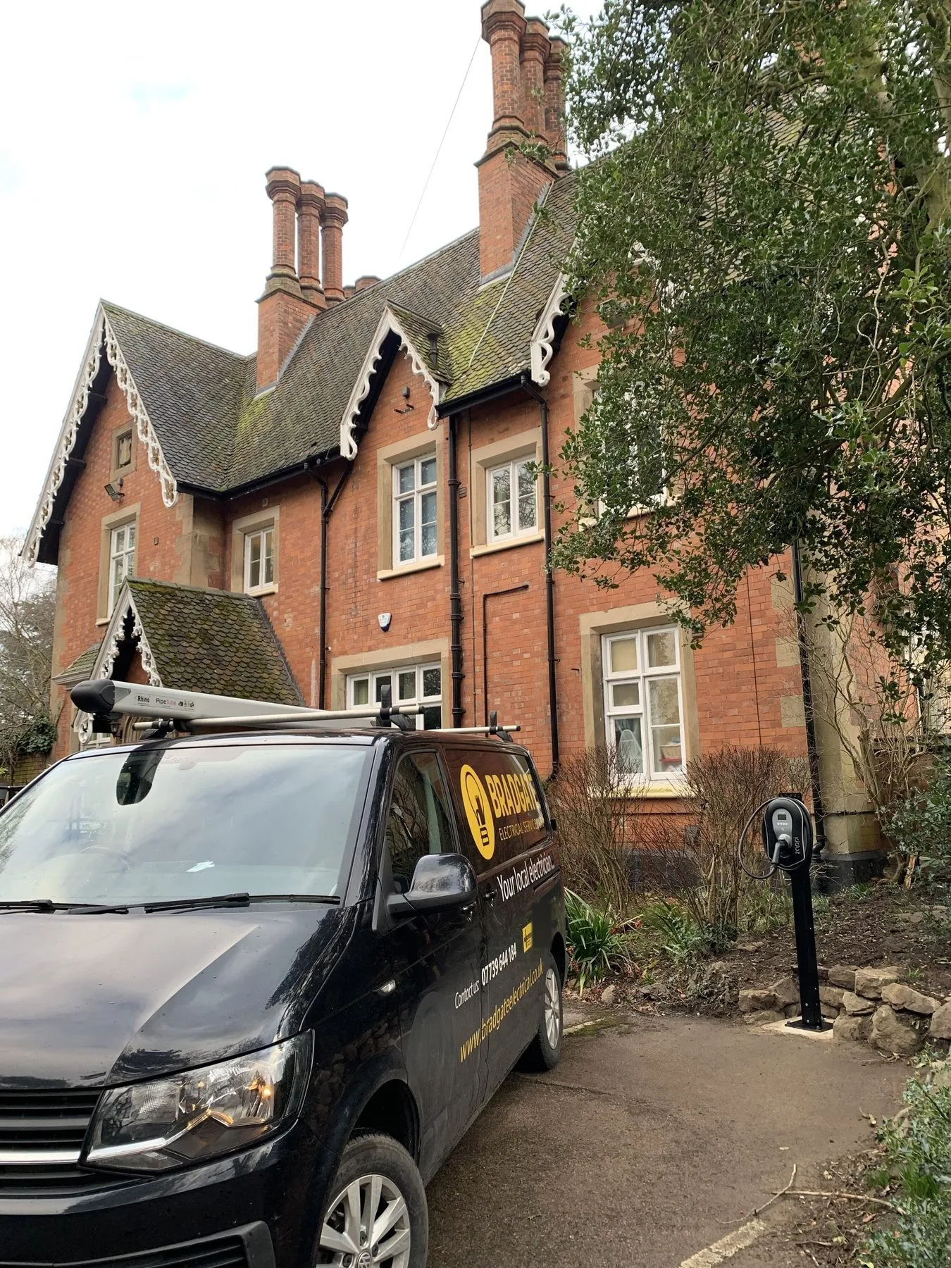 A Bradgate-fitted EV charger on a post at a Victorian house, with the Bradgate van on the drive