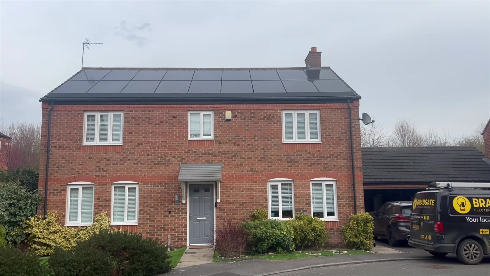 A home in Wymeswold with all-black solar panels on the roof and a Tesla Powerwall in the garage, with the Bradgate van on the drive