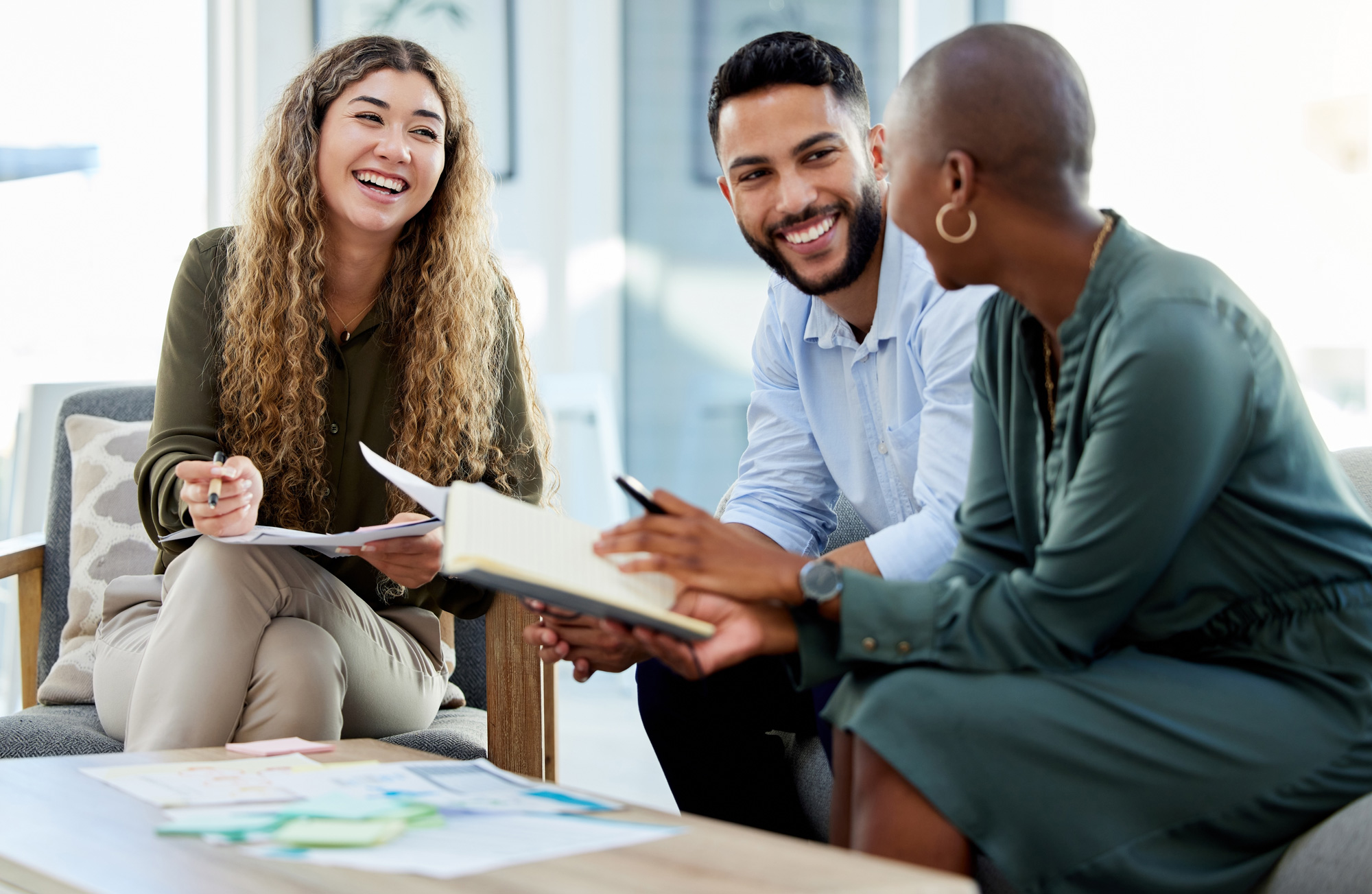 Group of people seated around a table holding bags with 'Spring Back Returnity Coaching' text.