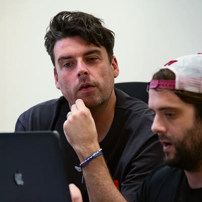 Two men looking at a laptop screen.