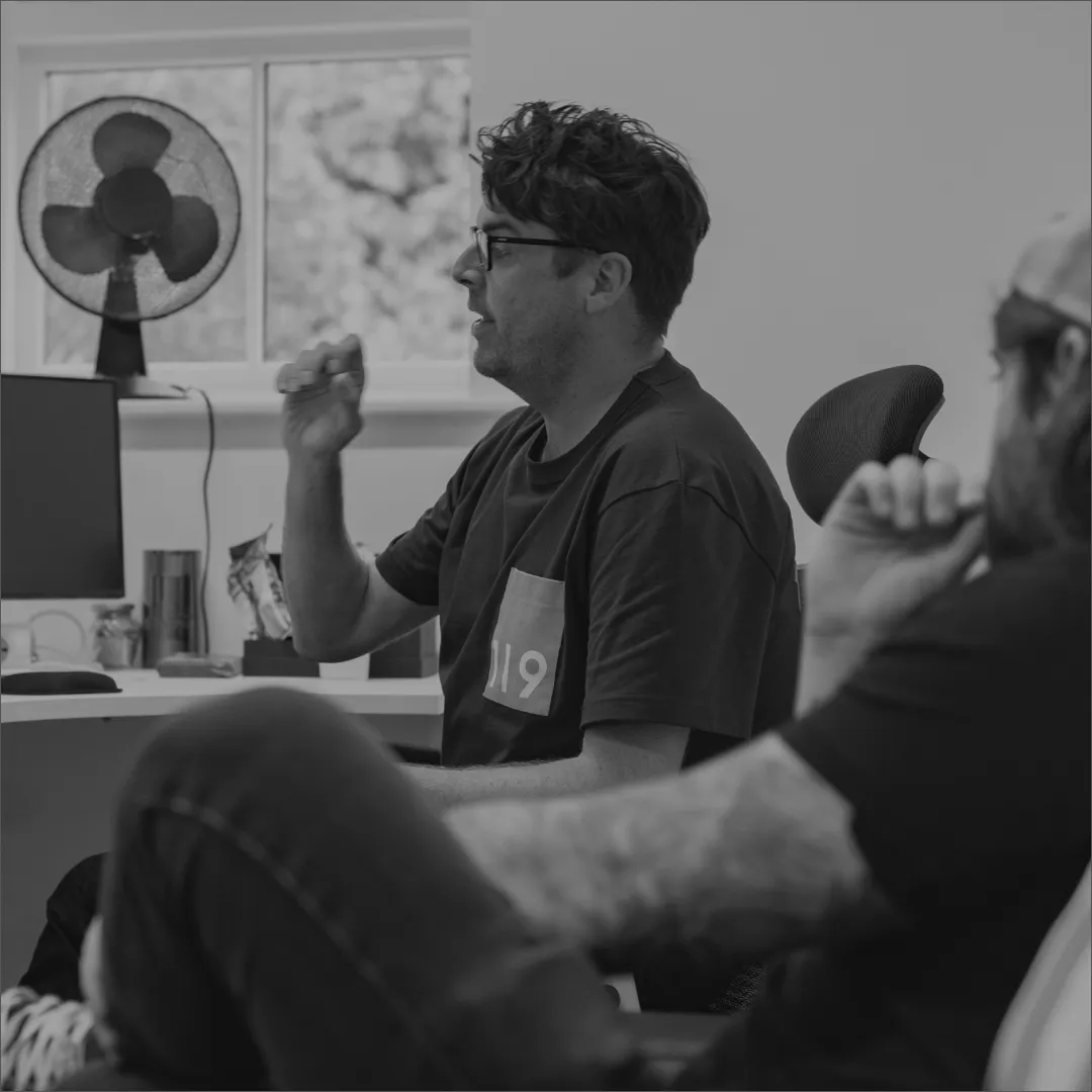 A man with a beard and glasses sitting in a chair.