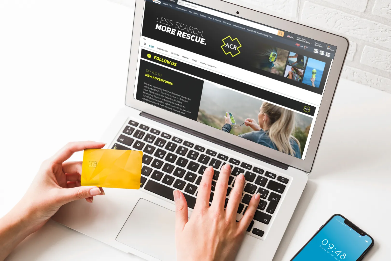 A person is typing on a laptop with a yellow card in front of them.