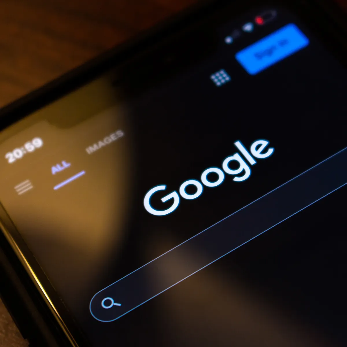 A cell phone with the Google search bar on the screen.