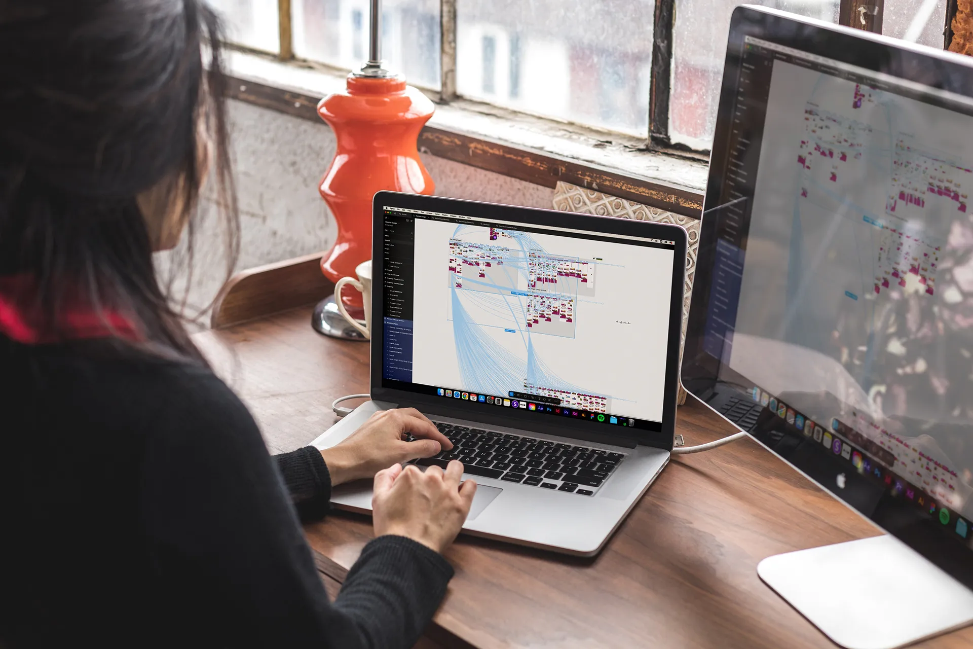 A woman is typing on a laptop with a window open to a graph.