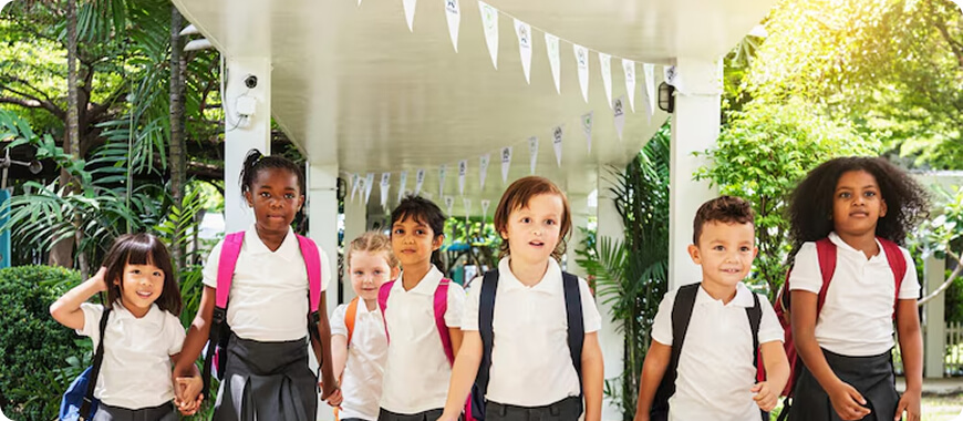 Diverso grupo de alumnos con uniforme escolar caminando juntos