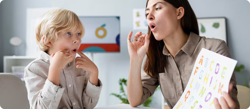 A teacher demonstrating mouth movements to help a child practice English pronunciation.