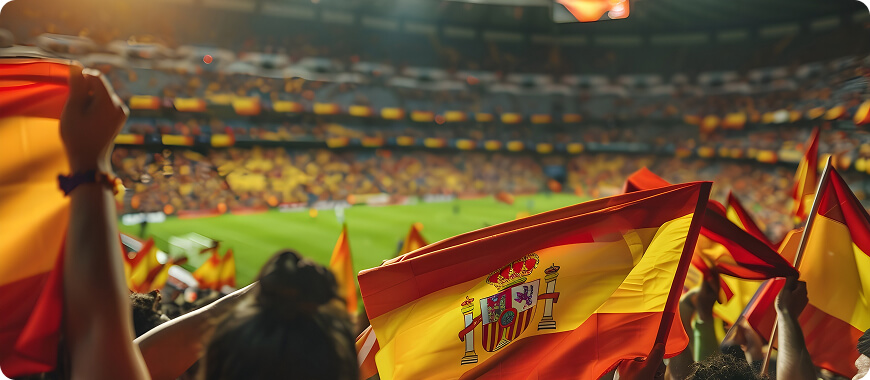 A lively soccer stadium filled with fans waving Spanish flags
