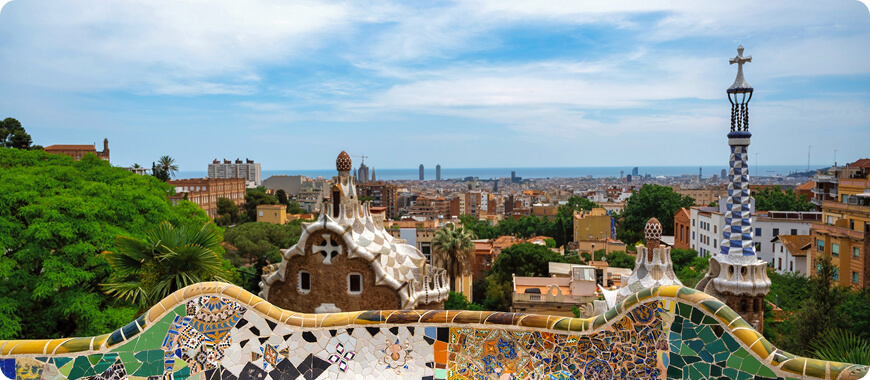 Panoramic view of Barcelona from Park Güell, showing colorful mosaics — a fun way for kids to learn English through Spanish culture and landmarks.