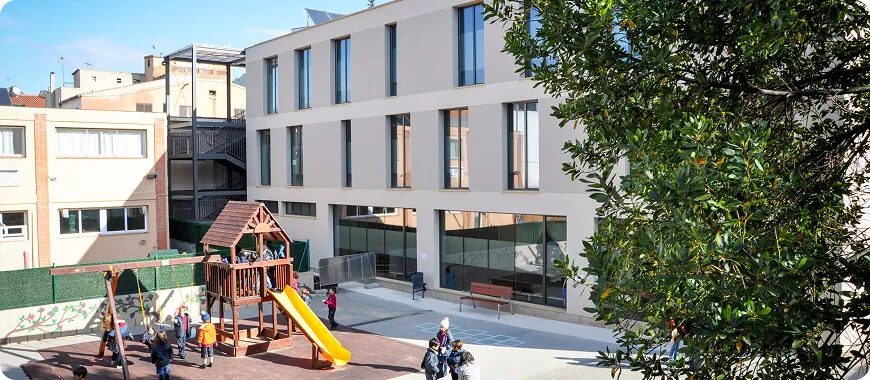 Entorno lúdico y educativo en la ISC Moderno campus de la Escuela Internacional de Cataluña con parque infantil y entorno verde