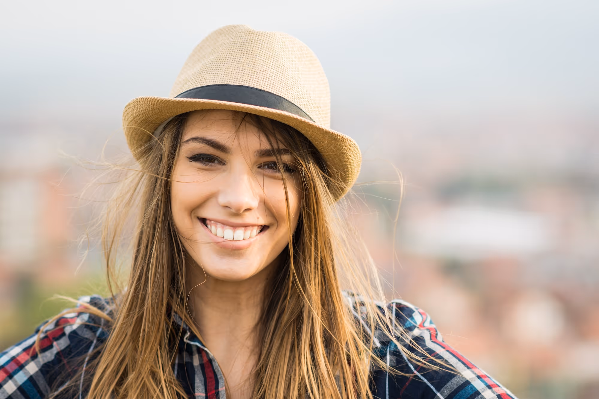 A woman with long hair wearing a hat.