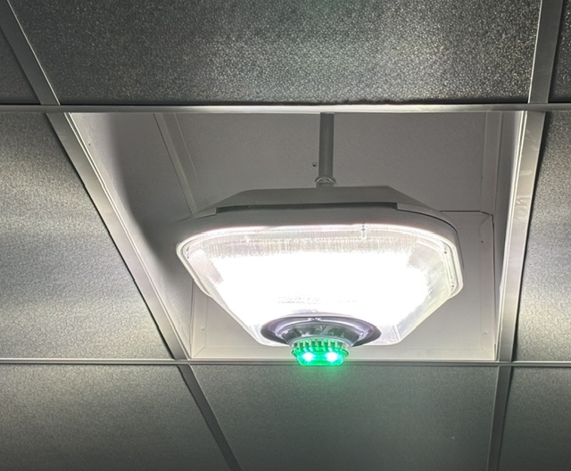 ECO Parking EDGE ceiling light fixture with bright white and green lights on a drop ceiling with square tiles.
