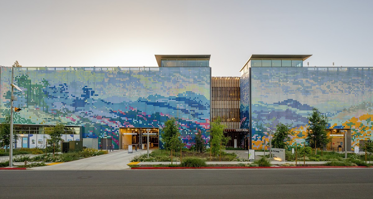 Modern parking garage with colorful mosaic mural and trees in front at 1001 Alta with ECO Edge Light Fixtures Installed Inside