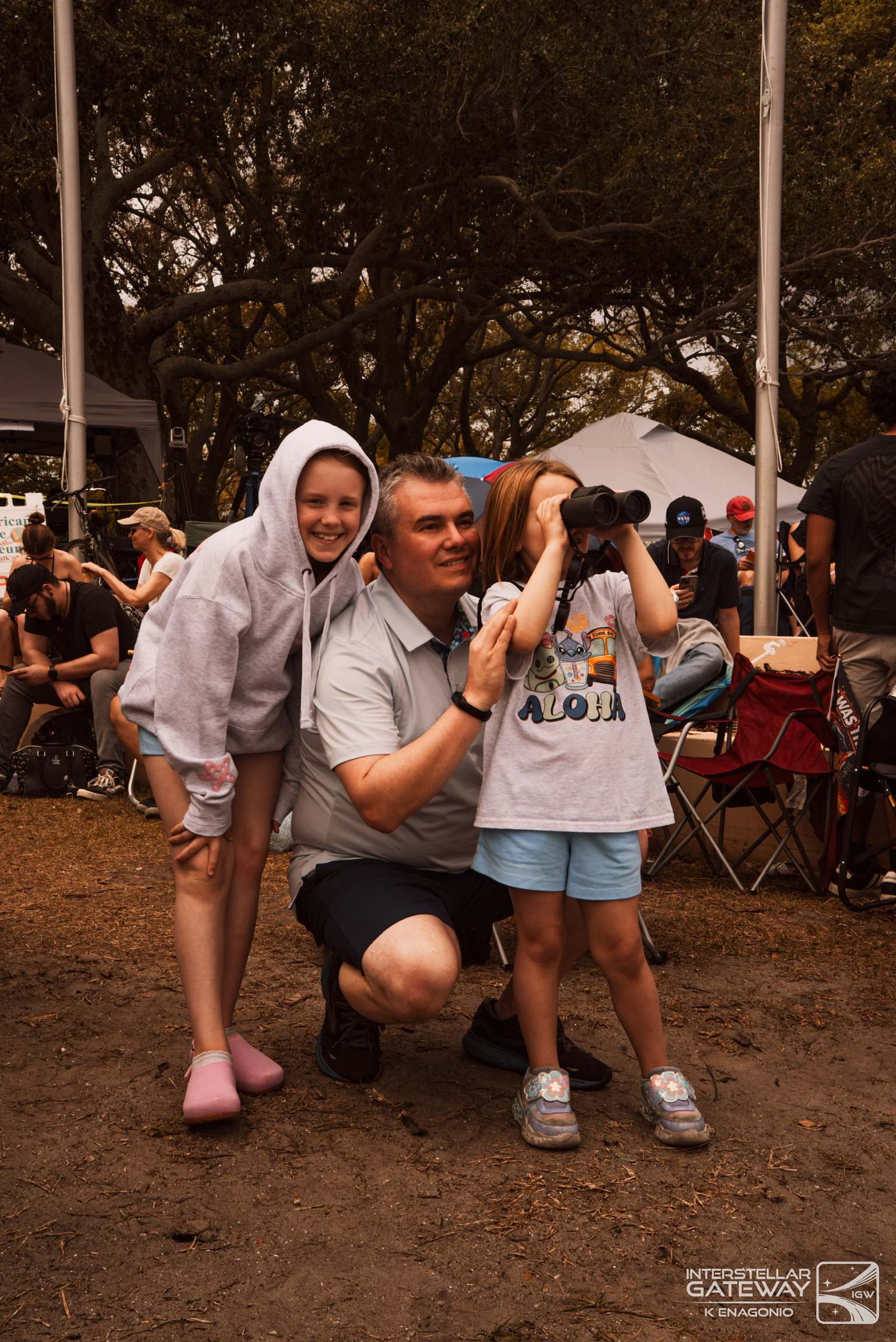 A family poses in front of the crowd at a launch viewing site.
