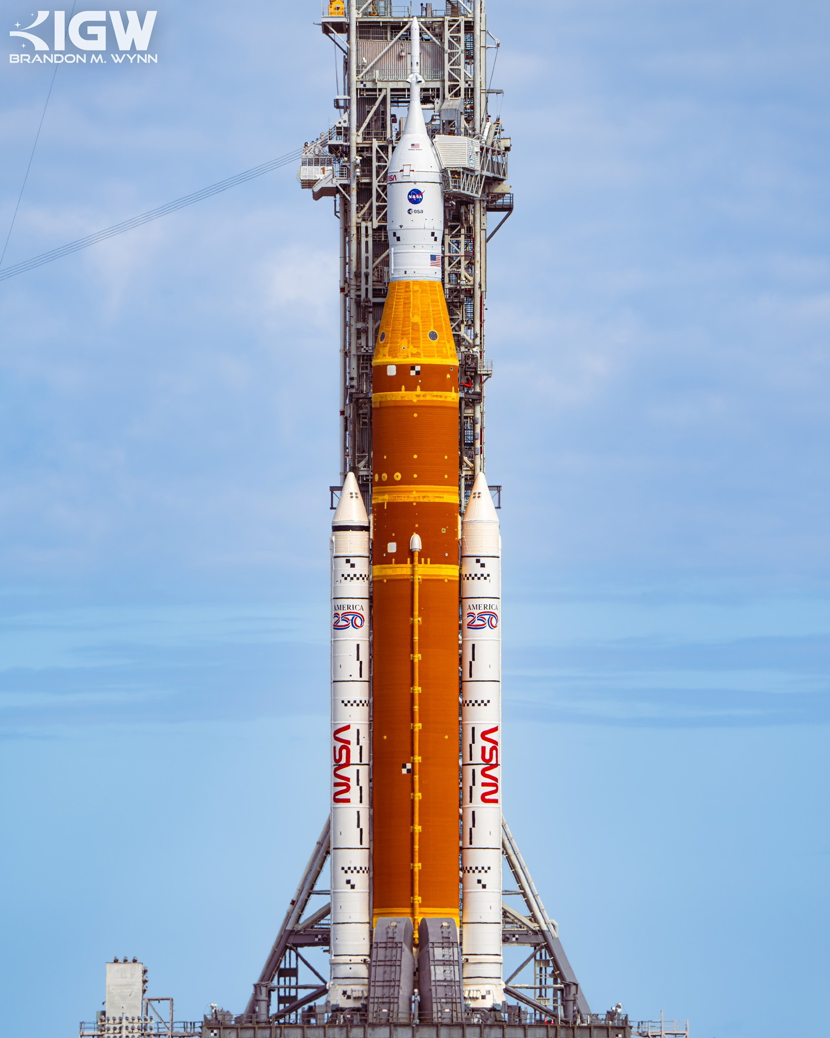 The Space Launch System on its mobile launcher in daylight, seen from the front.
