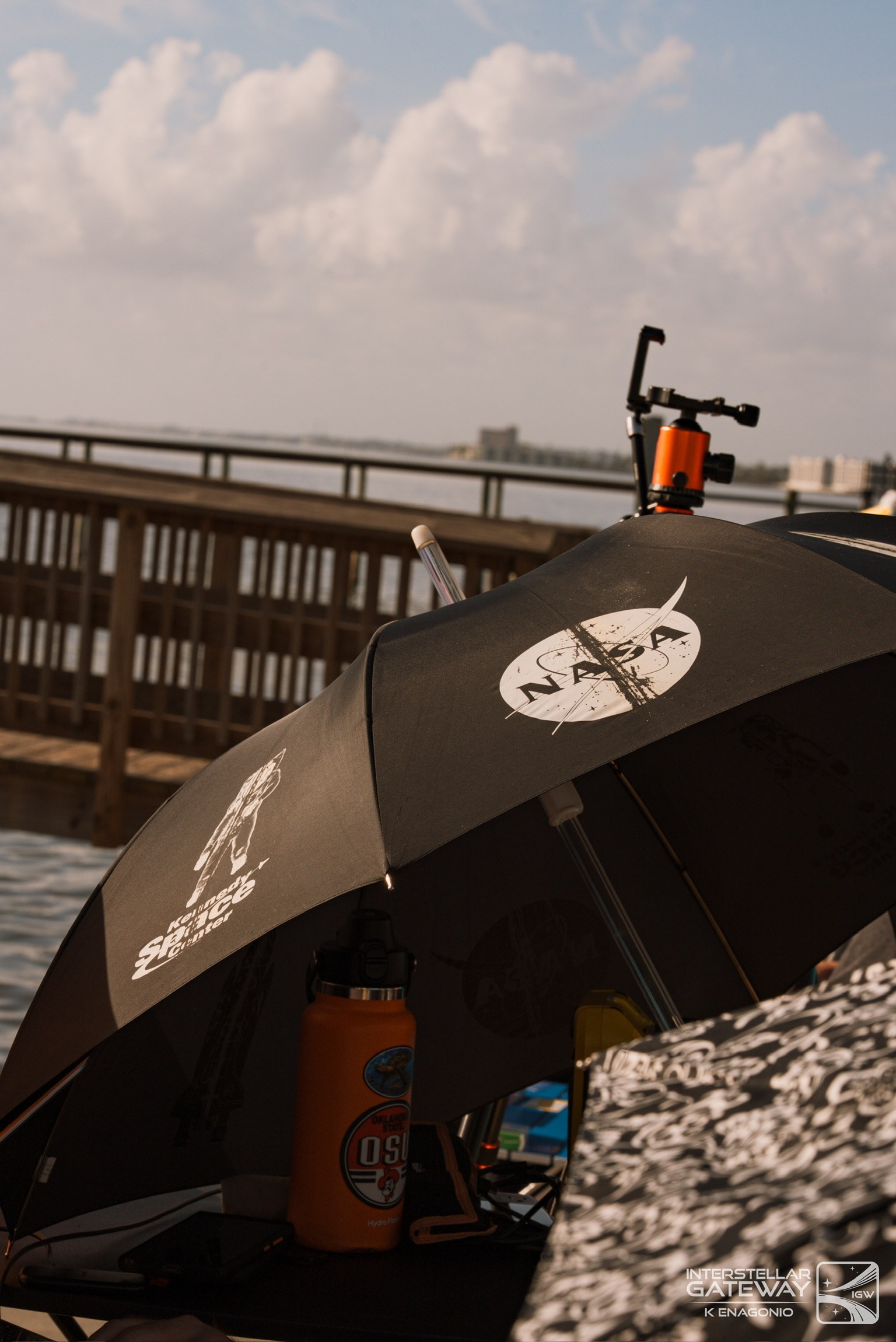 NASA umbrellas and cameras set up on a pier beside the water.
