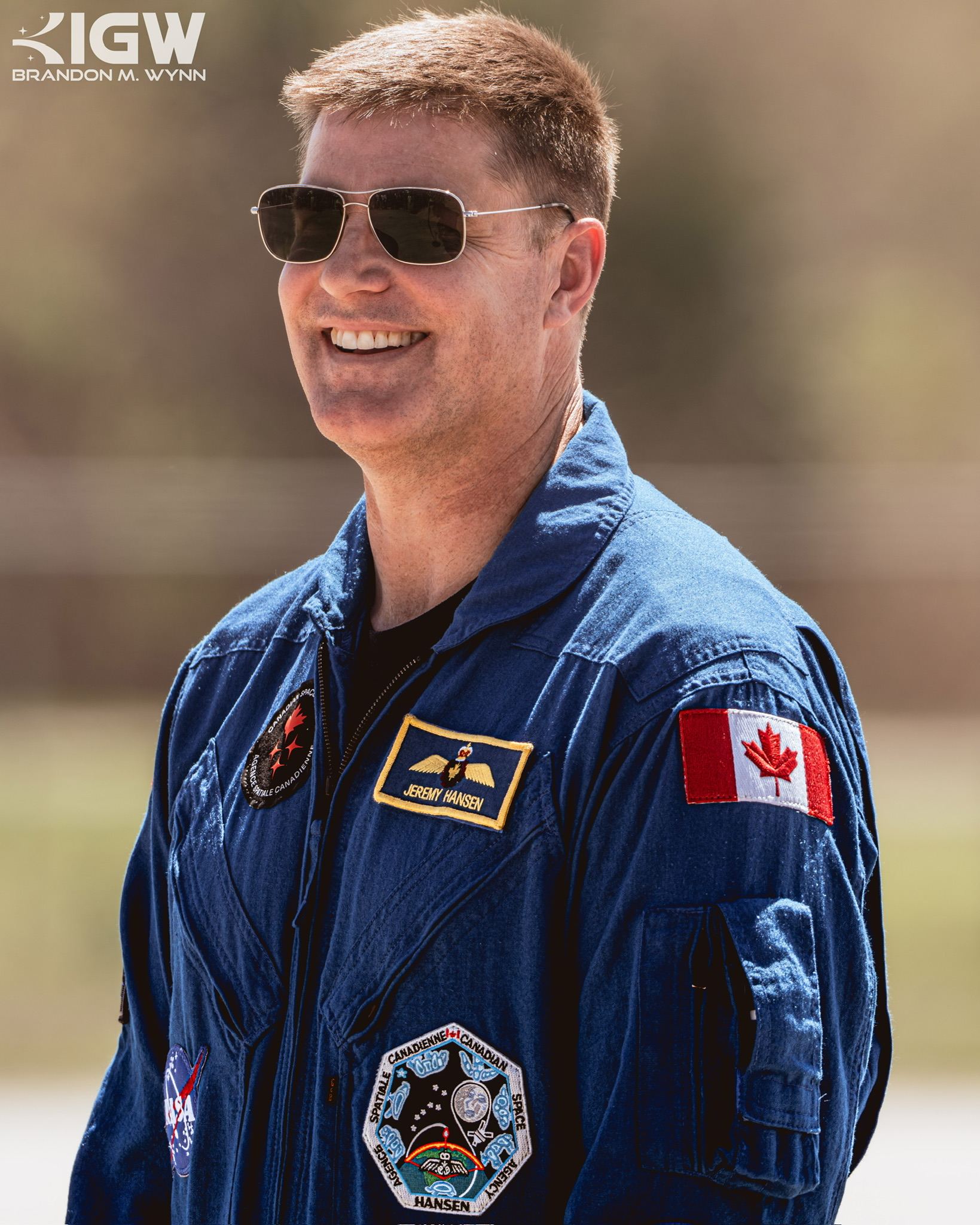 Jeremy Hansen in a blue flight suit with the Canadian flag on the shoulder.