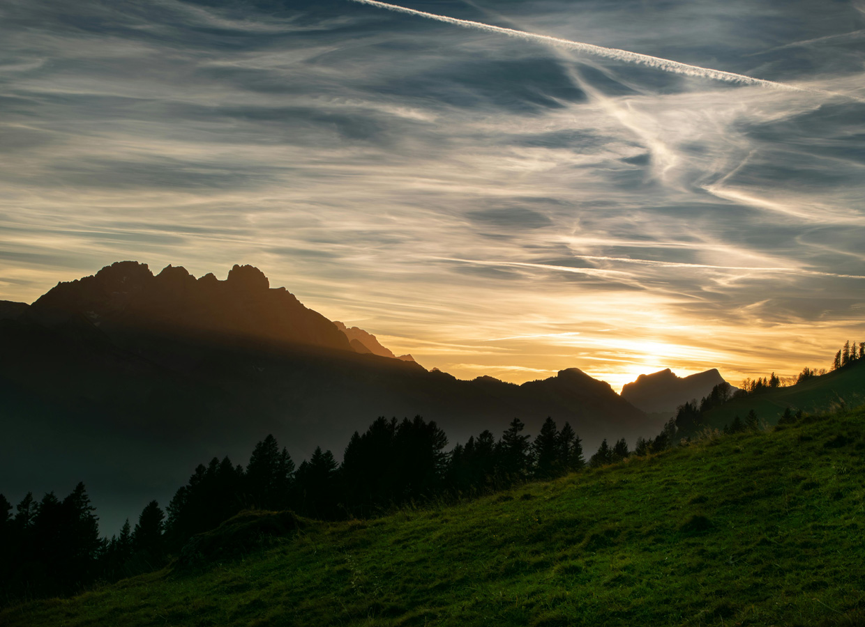 Weite Berglandschaft im Licht der untergehenden Sonne als Symbol für Perspektive, Orientierung und langfristige Entwicklung
