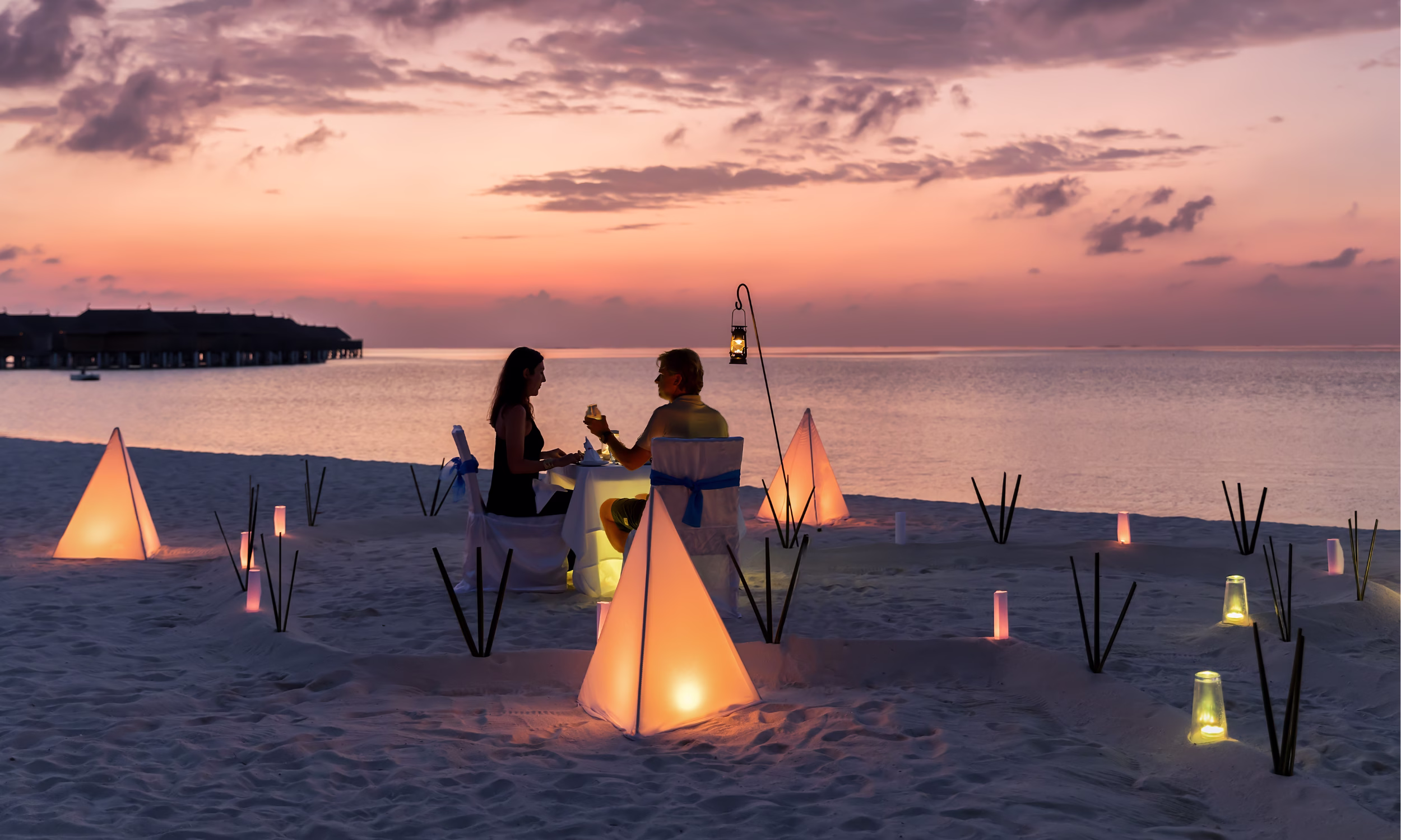 Romantic beach dinner in Zanzibar at sunset, perfect for honeymoon couples.