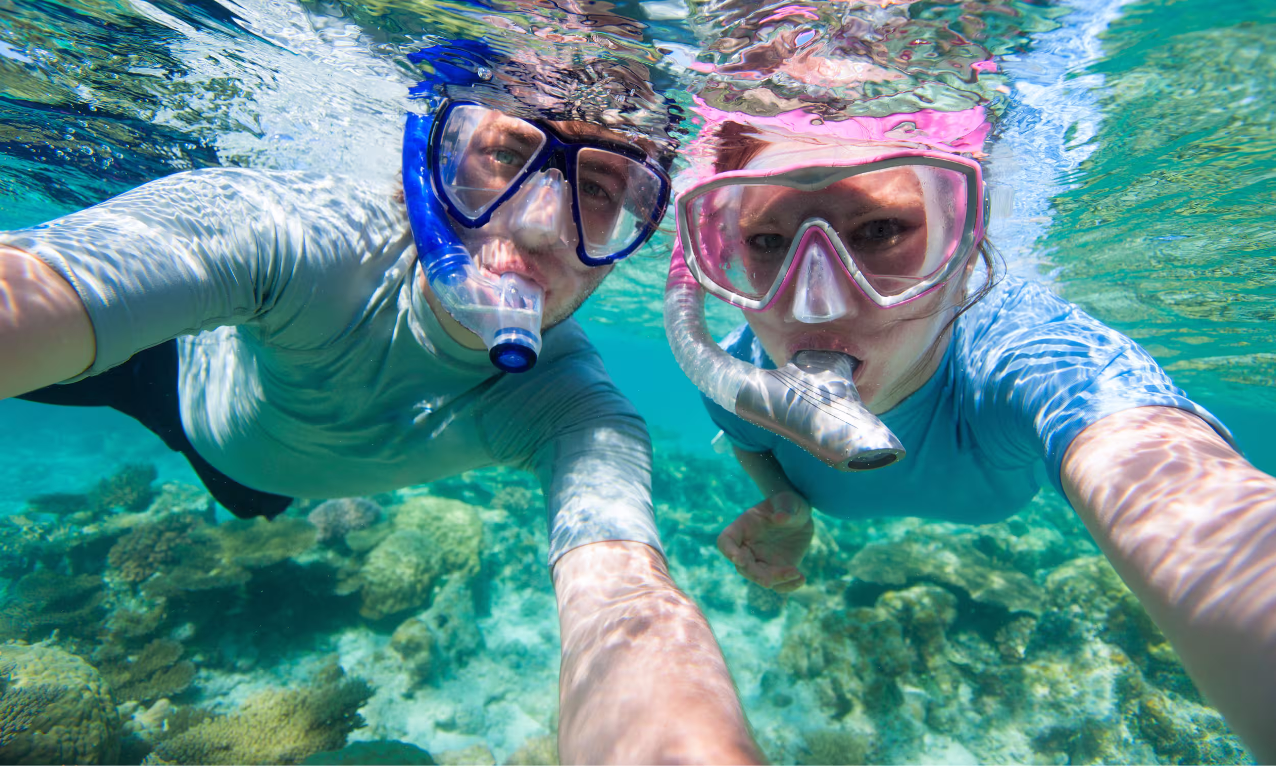 Honeymoon couple snorkeling in the clear waters of the Maldives.