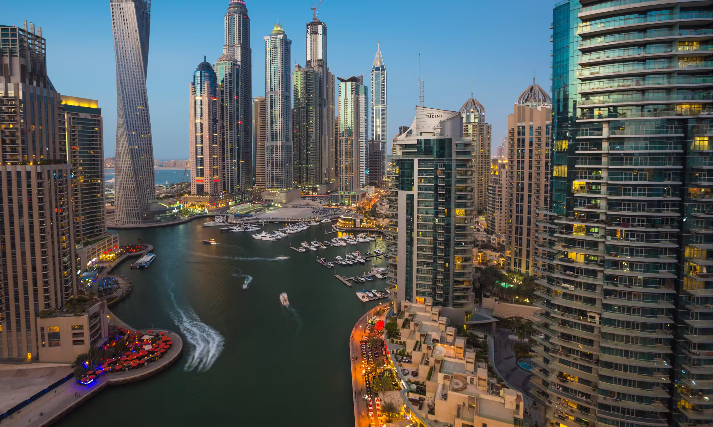 Dubai Marina lit up at night, reflecting luxury and romance.