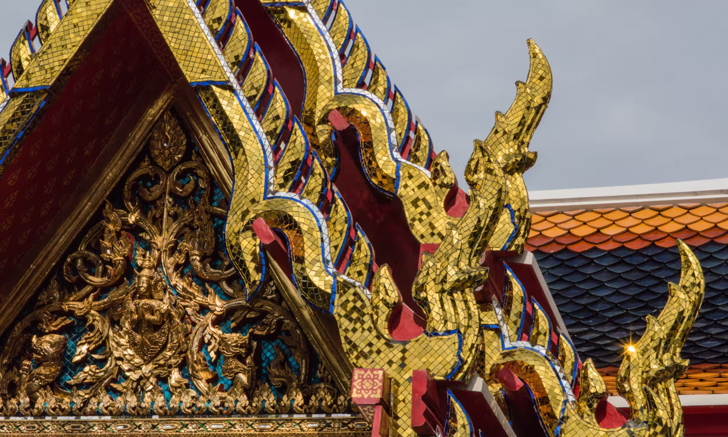 Golden ornamental details of a traditional Thai temple with intricate carvings. 