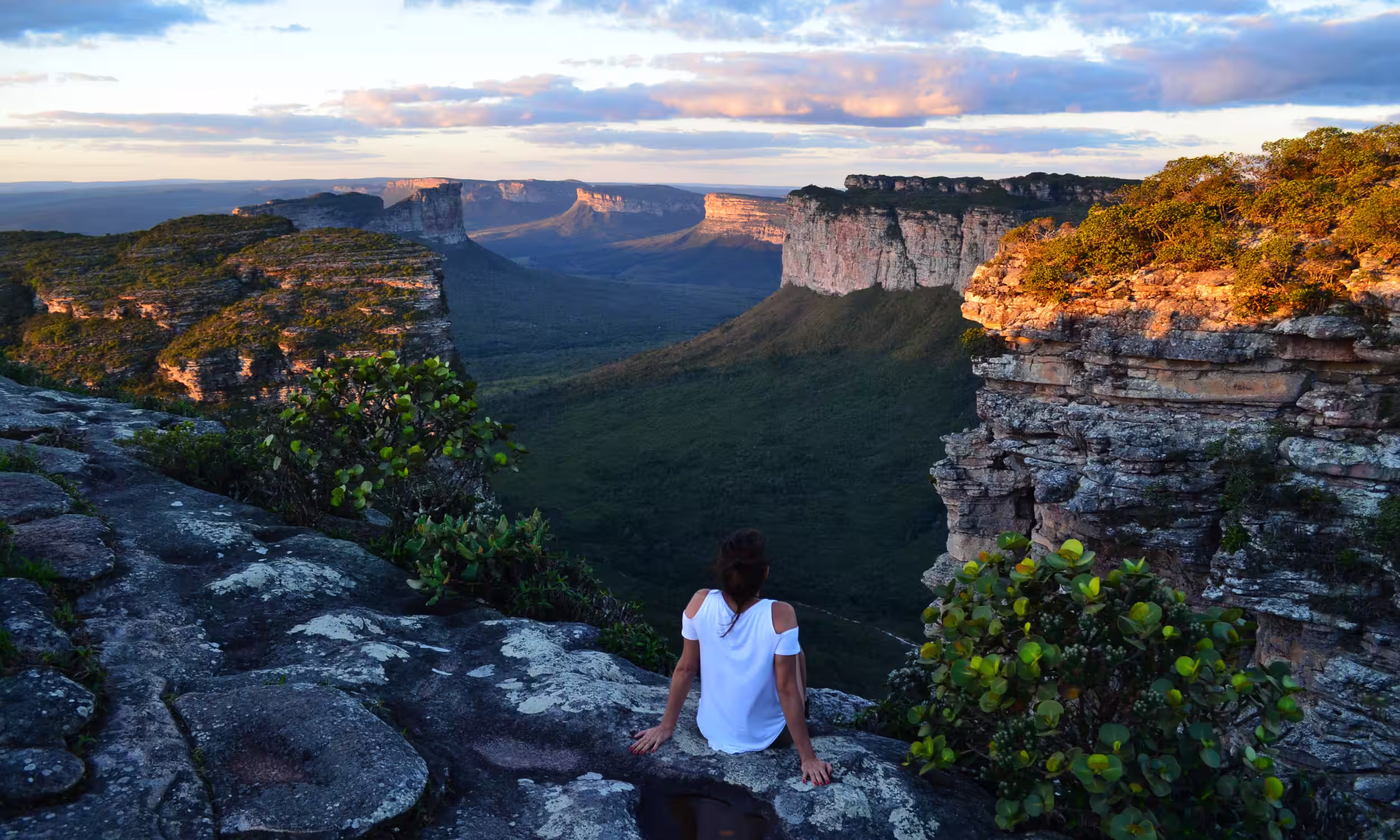 Couple sitting on a cliff overlooking the valleys of Chapada Diamantina, Bahia. 