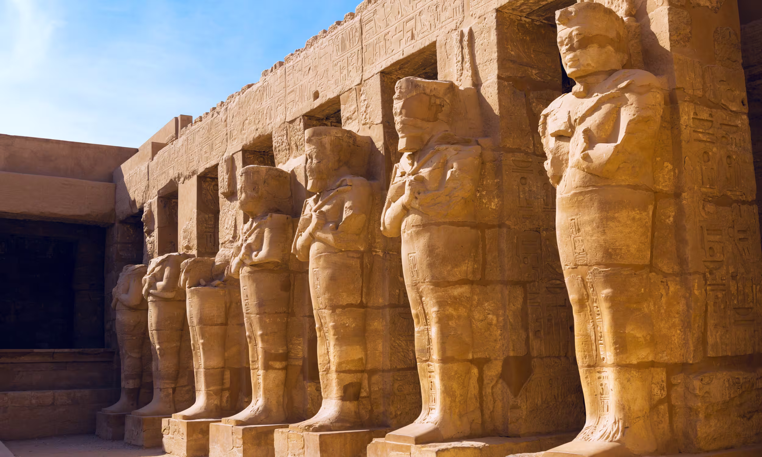 Columns and statues of Luxor Temple glowing in the warm afternoon light.