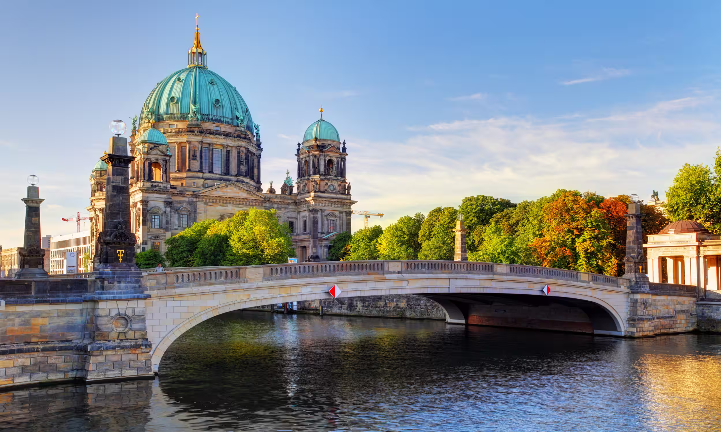 Berlin Cathedral viewed from Friedrichsbrücke Bridge with golden reflections on the river. 
