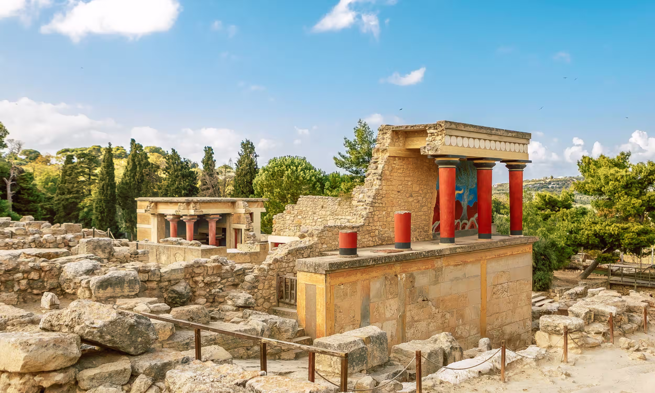 Ruins of the Palace of Knossos in Crete under a bright blue sky. 