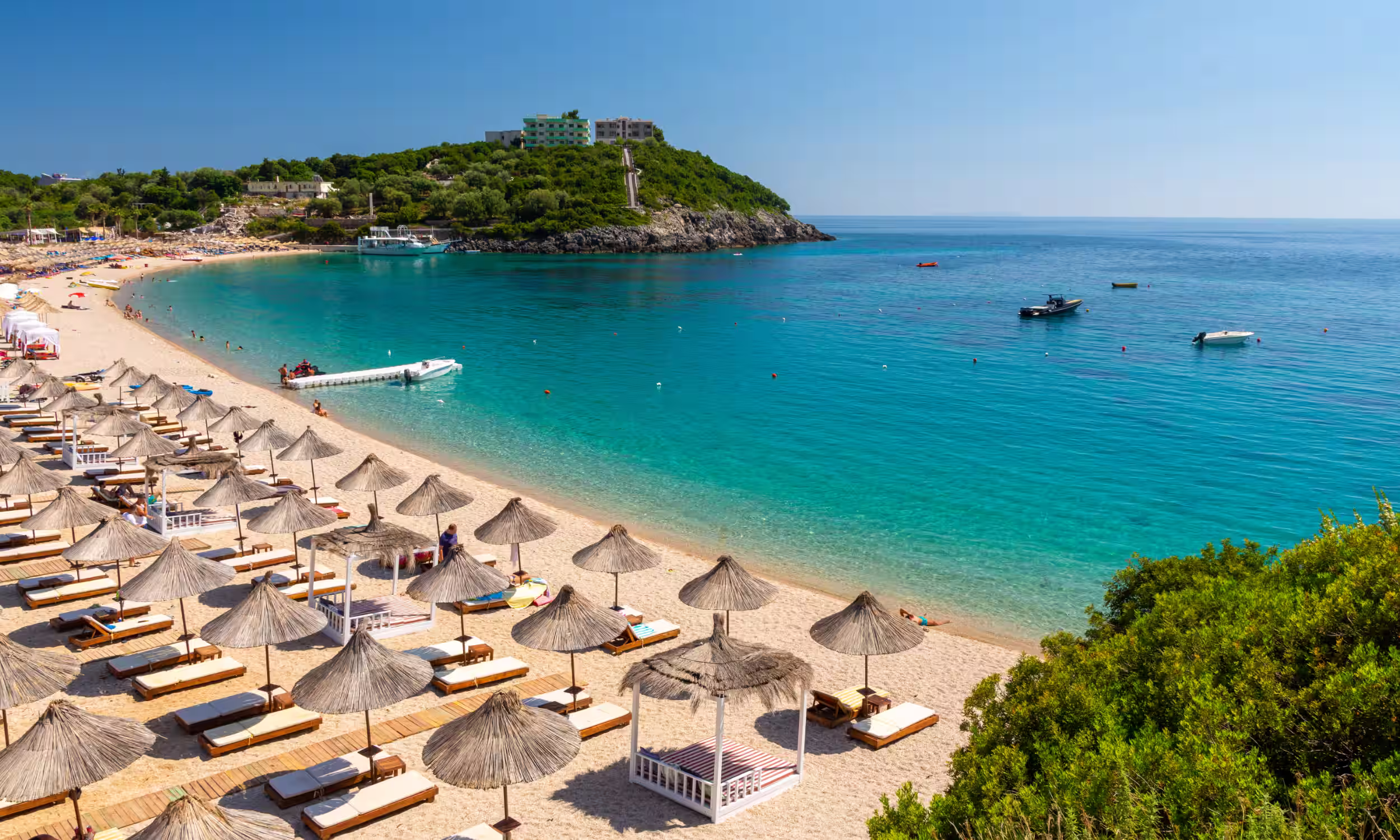 Jale Beach with white sand and sun loungers by the sea — ideal for couples on an Albania honeymoon. 