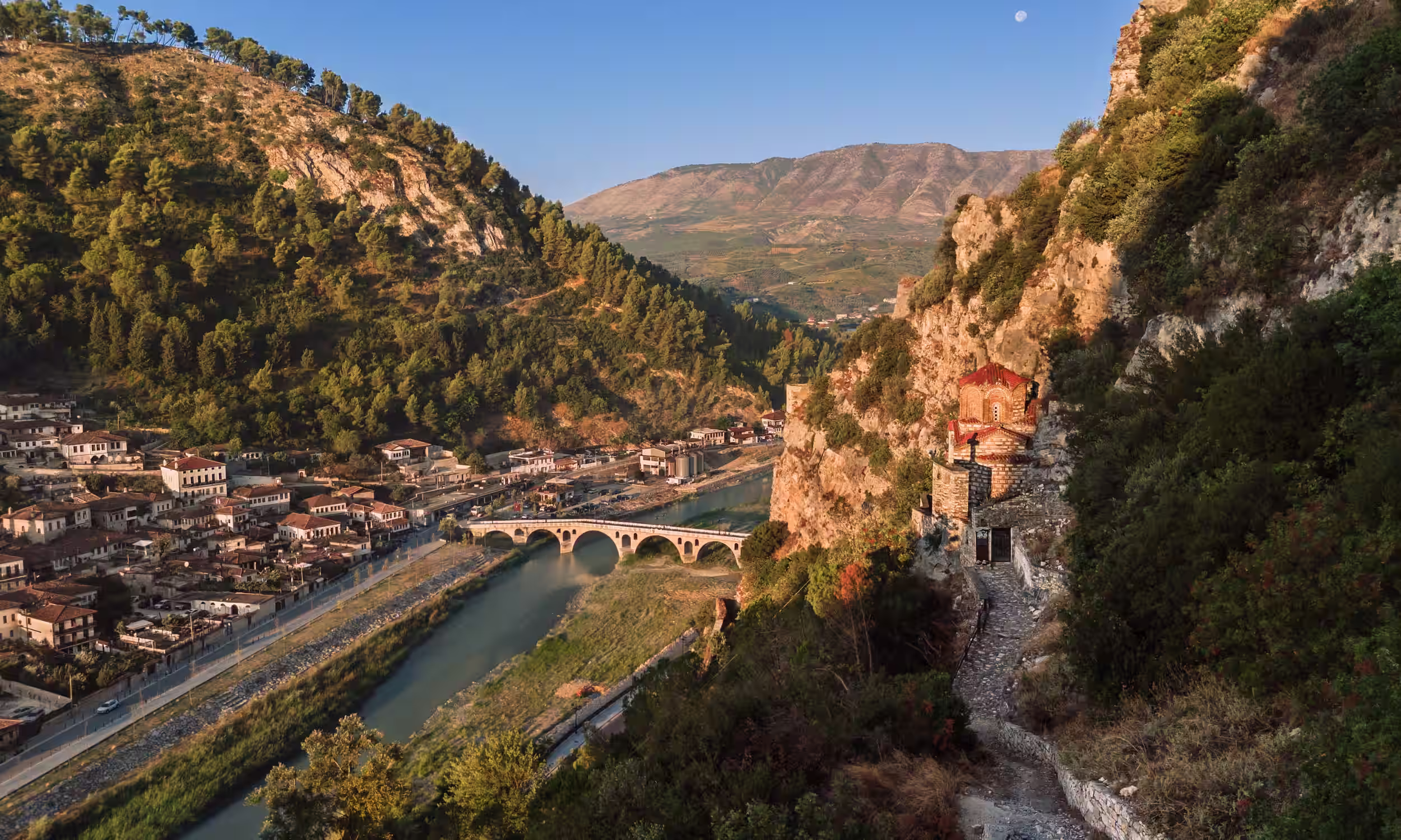 Panoramic view of Gjirokastër nestled between mountains — heritage and charm in Albania. 