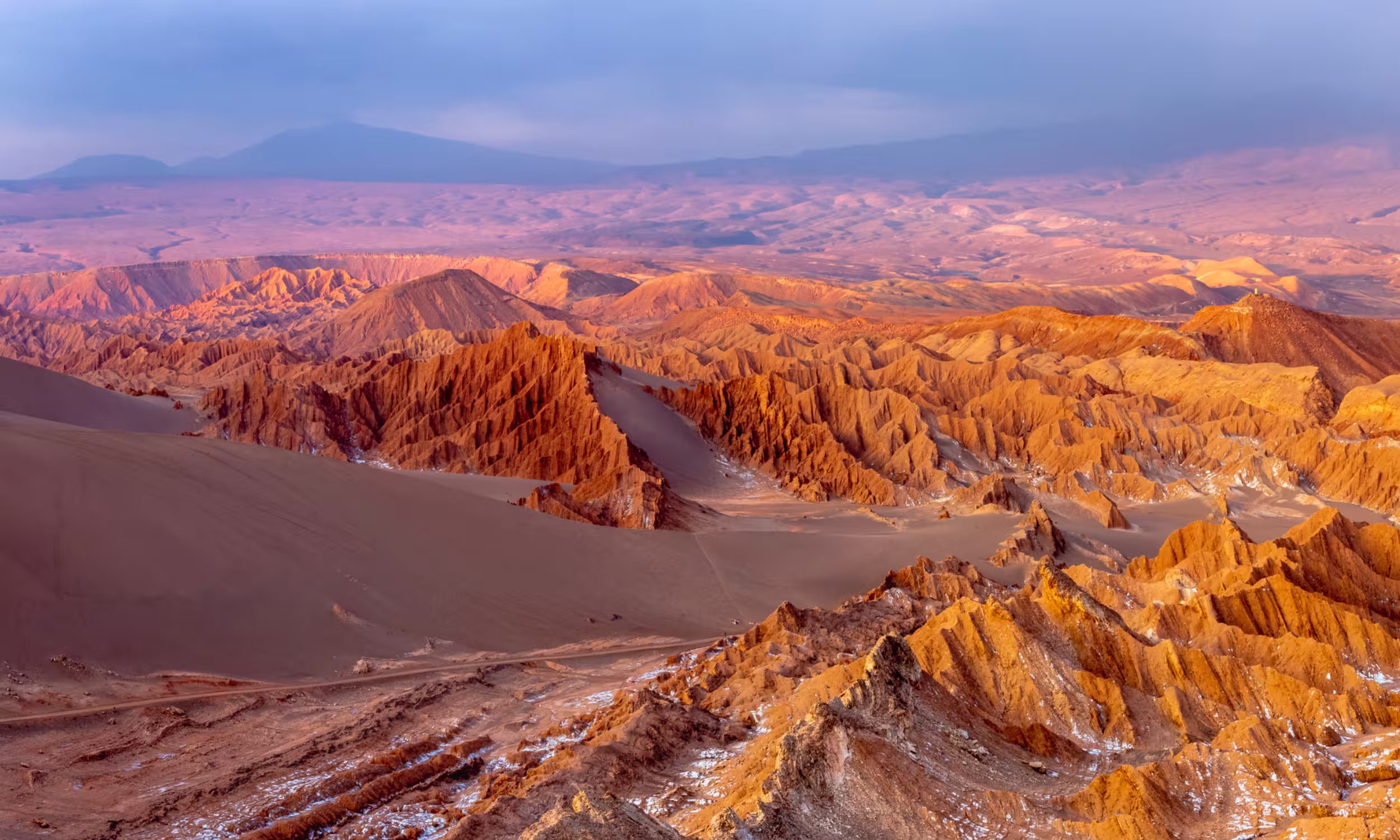 Desert landscape of the Moon Valley in Atacama with rock formations glowing at sunset. 