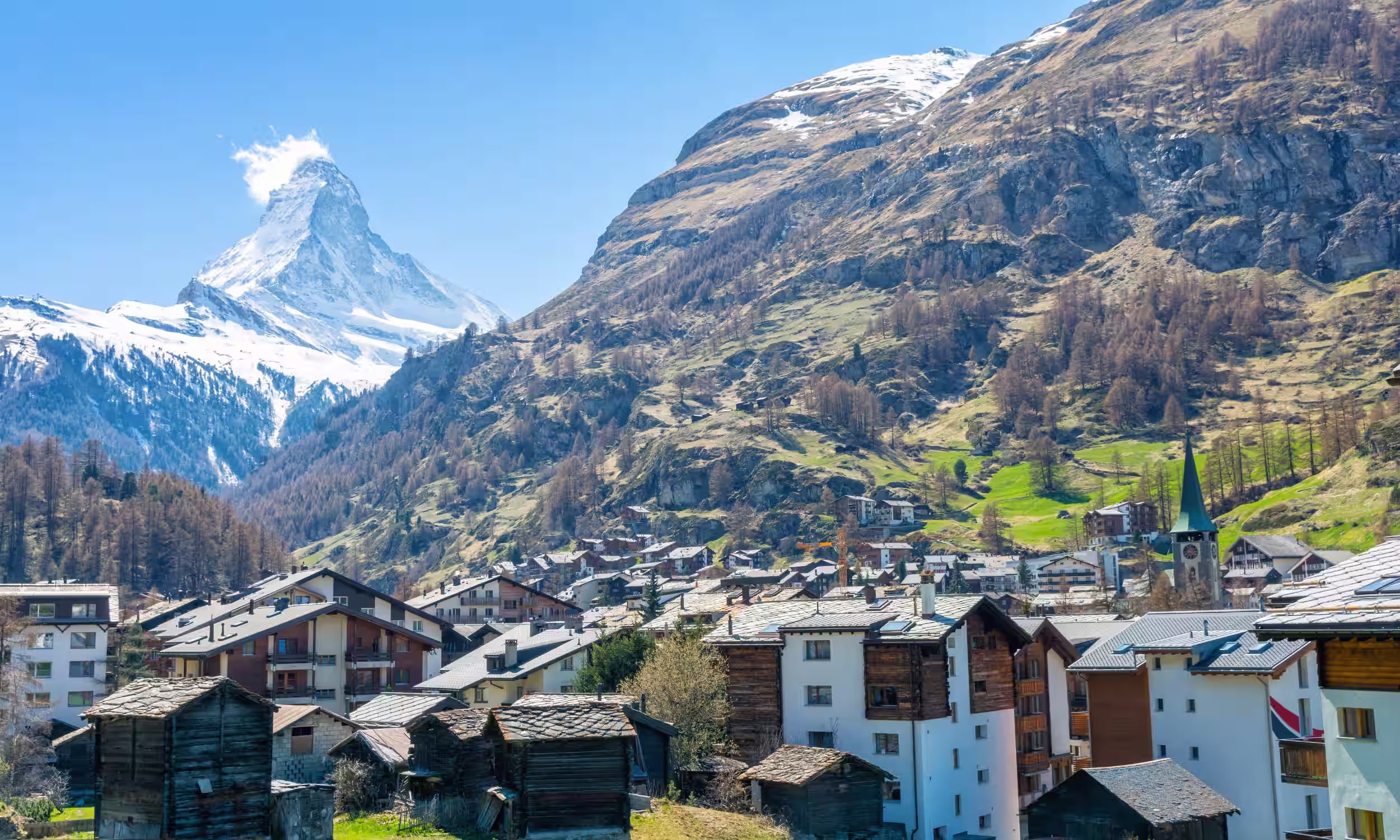 Matterhorn in the background with a snowy alpine village and mountains. 