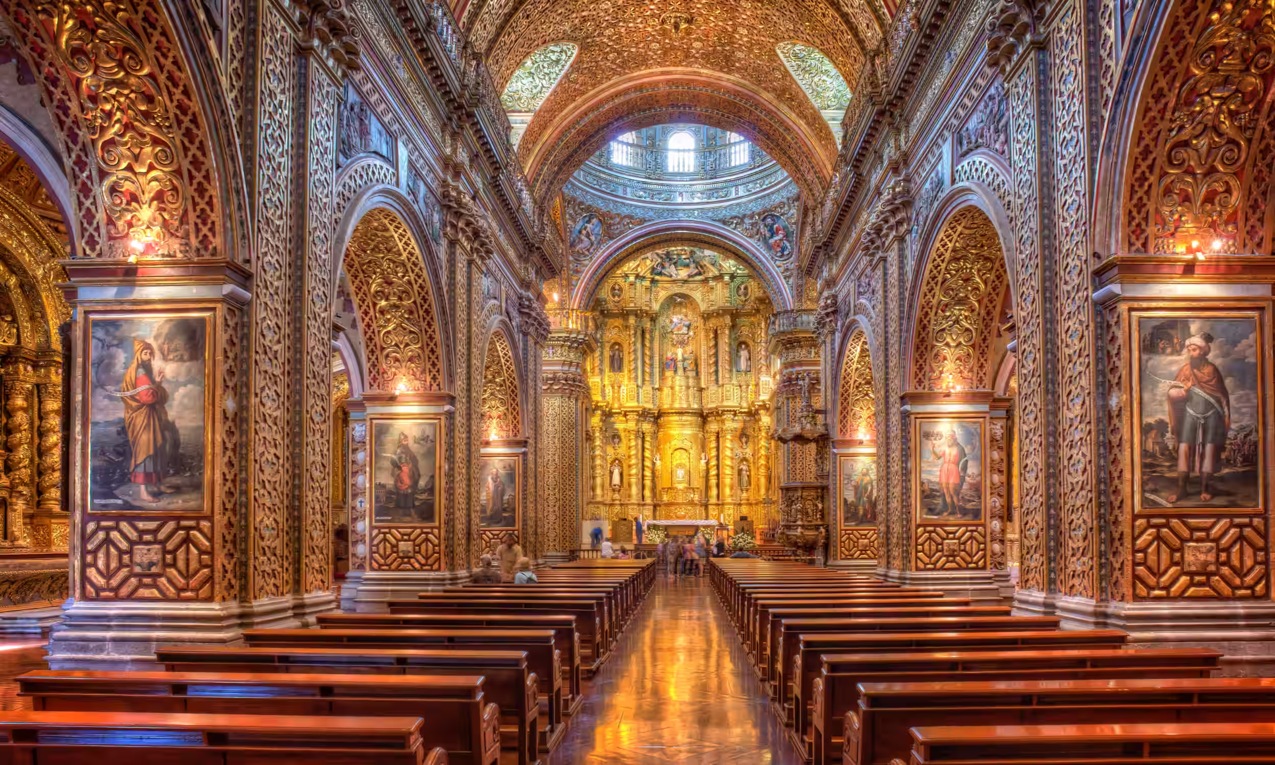 Interior of a historic church in Quito with golden ornamentation and colonial architecture. 