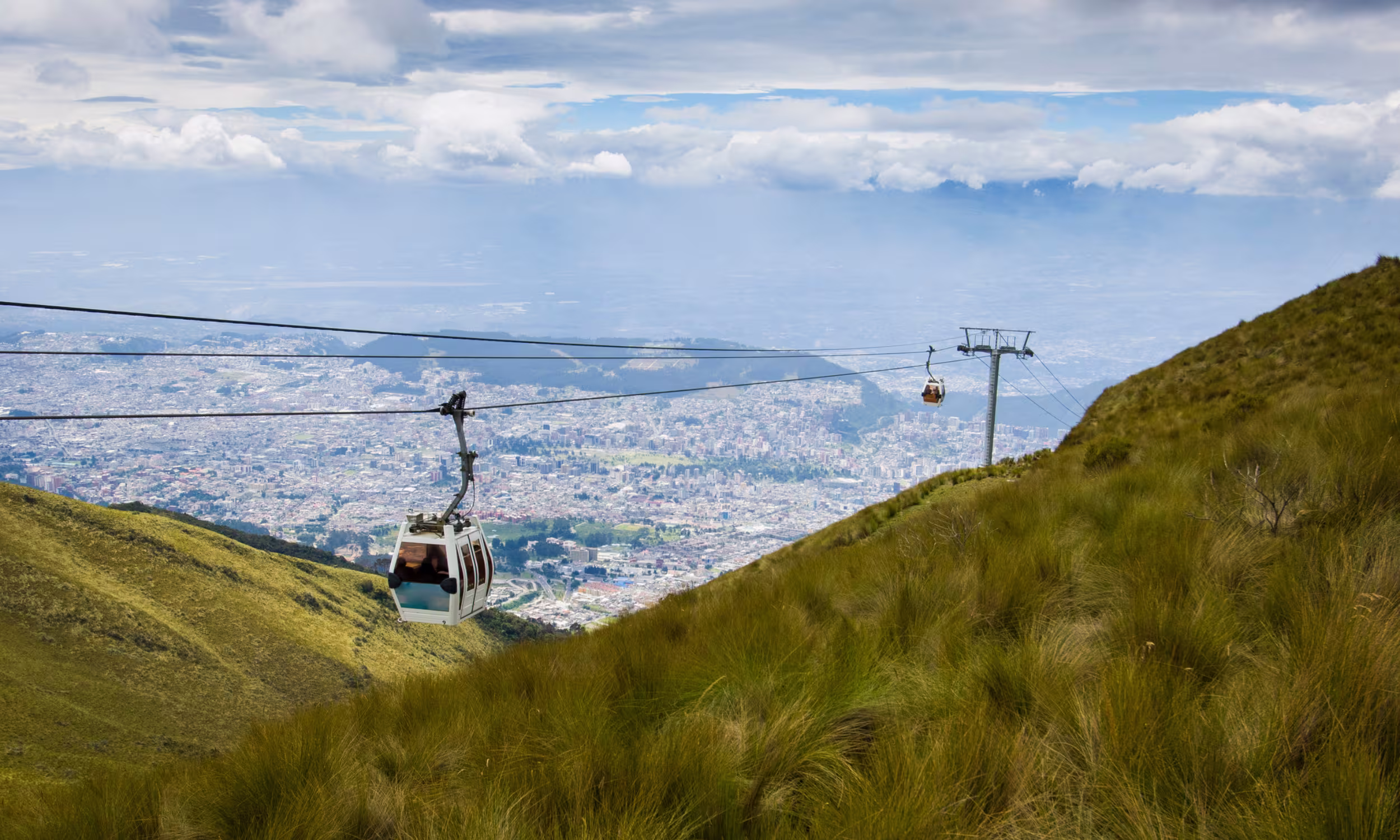 Gondola climbing the Andes with panoramic views over Quito.