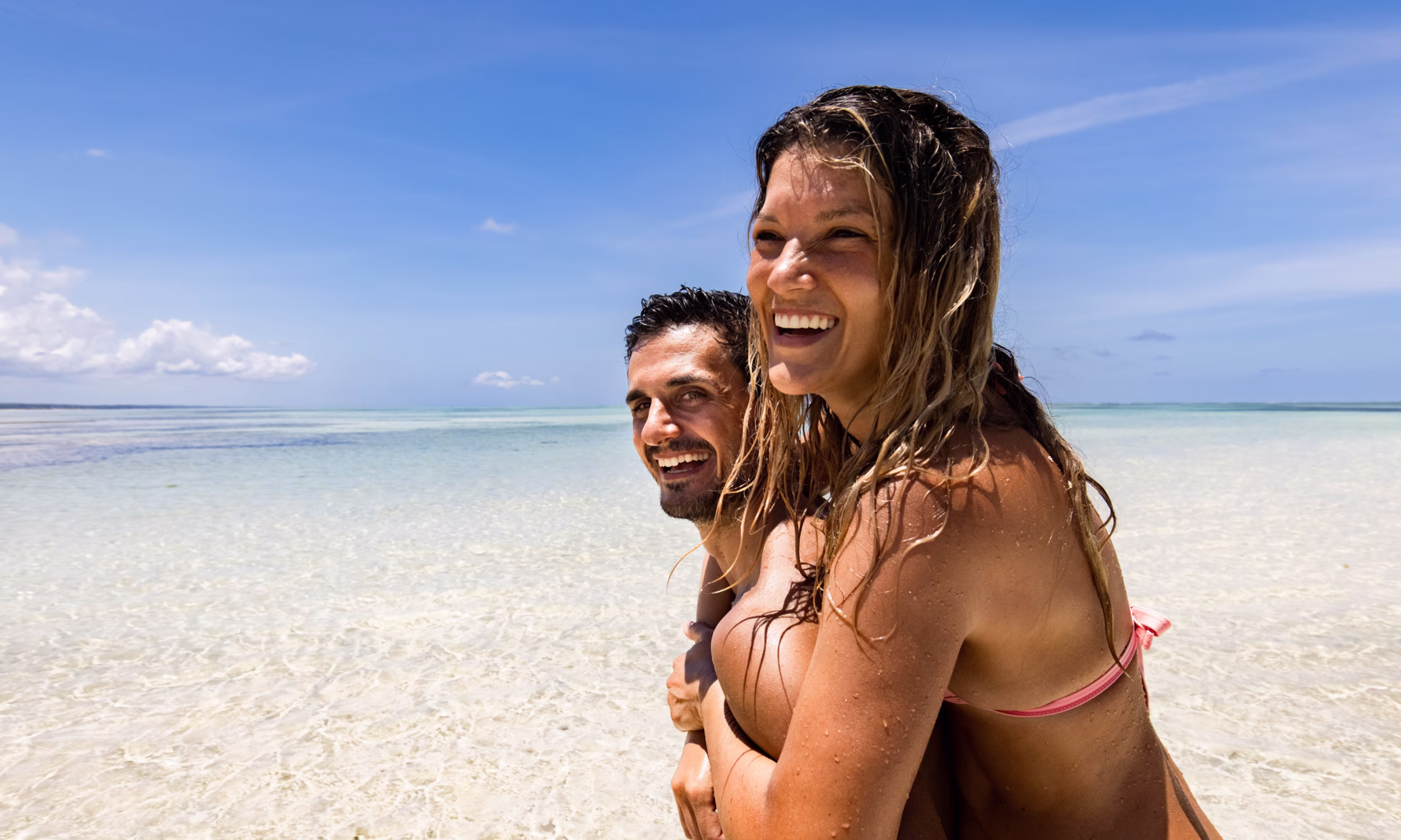 Couple embracing in the clear shallow waters of a paradise beach in Zanzibar. 