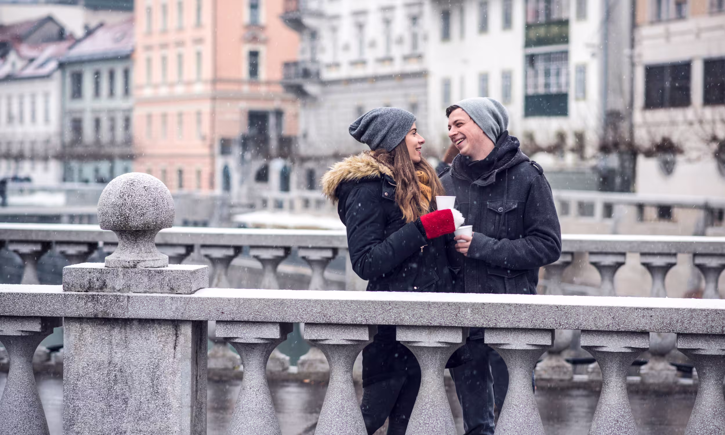Casal romântico em ponte histórica de Ljubljana, cenário urbano para lua de mel na Eslovénia 
