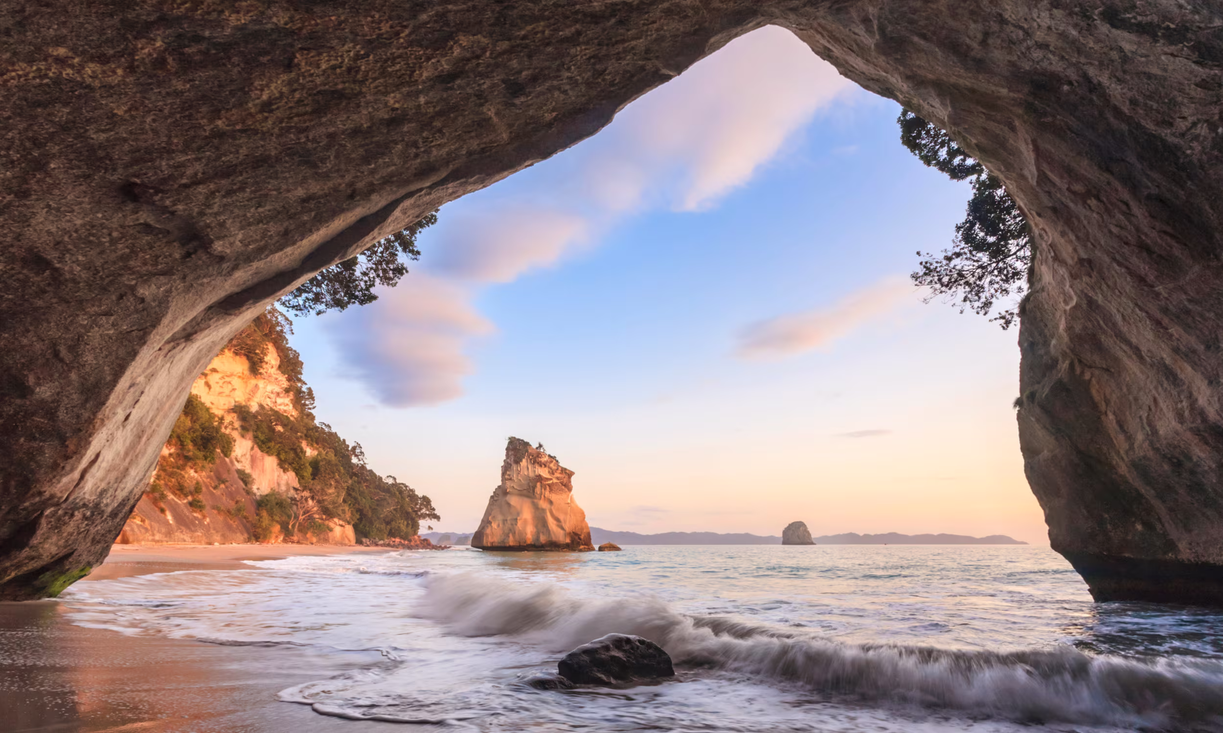 Cathedral Cove ao amanhecer na Nova Zelândia, cenário romântico para lua de mel 