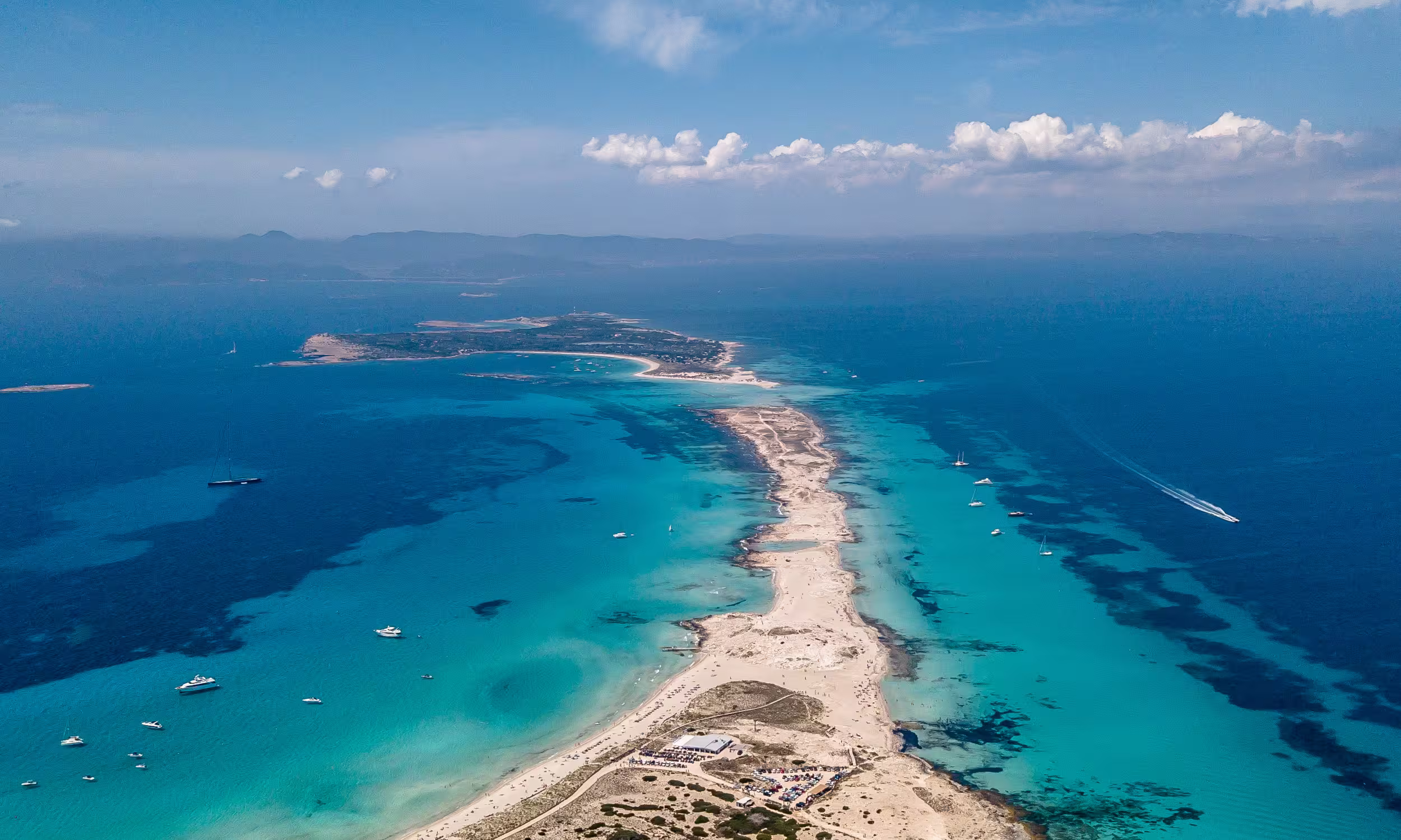 Mar azul-turquesa entre Ibiza e Formentera, cenário insular luminoso para uma lua de mel em Espanha.
