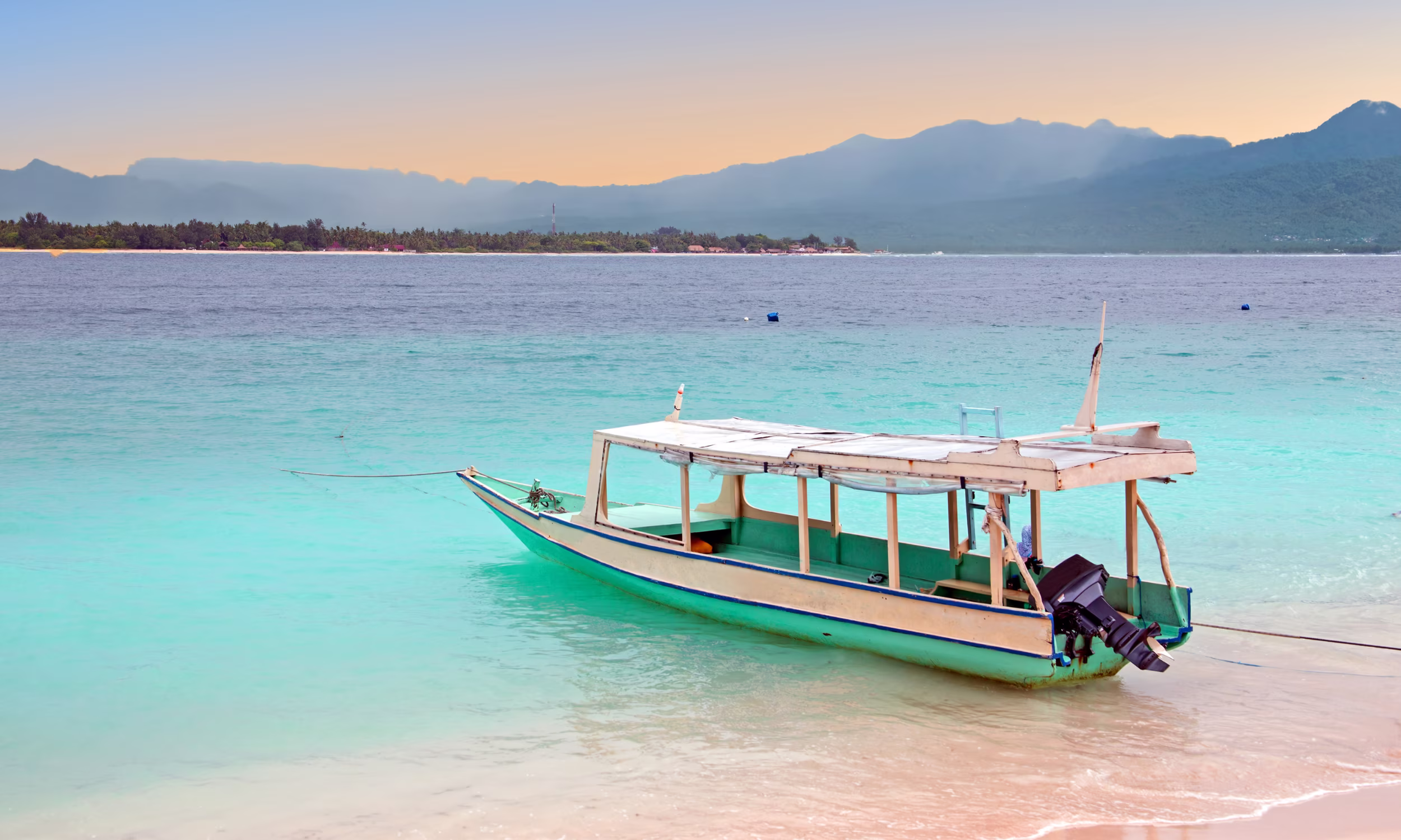 Traditional boat on the beach of Gili Meno, with calm sea and soft sand during a honeymoon in the Gili Islands.