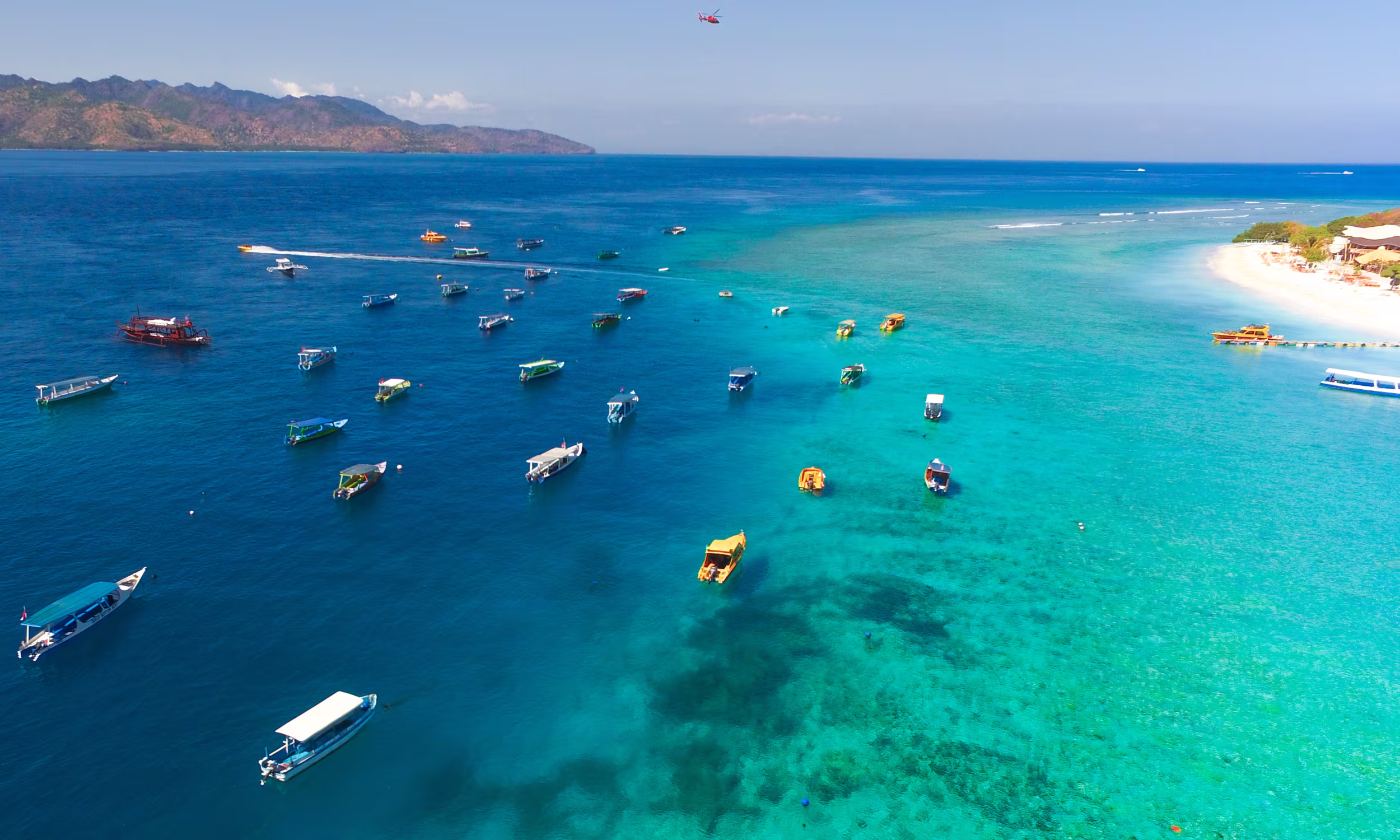 Tropical white sand beach with clear blue water in the Gili Islands, ideal for a relaxed honeymoon.