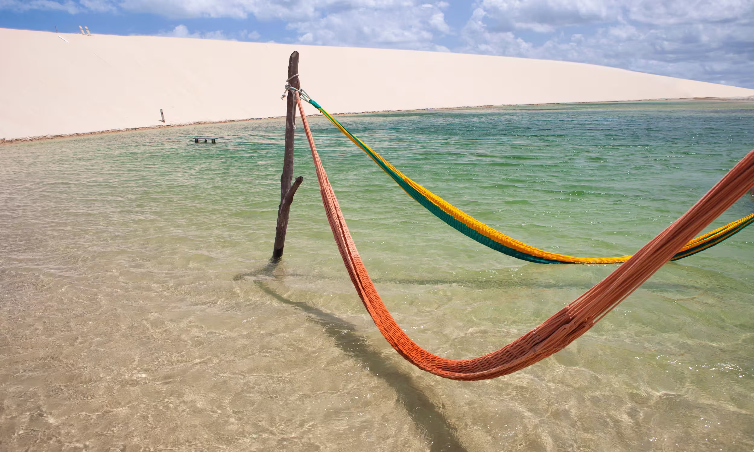 Hammocks in a clear lagoon in Jericoacoara, a peaceful tropical setting for couples.