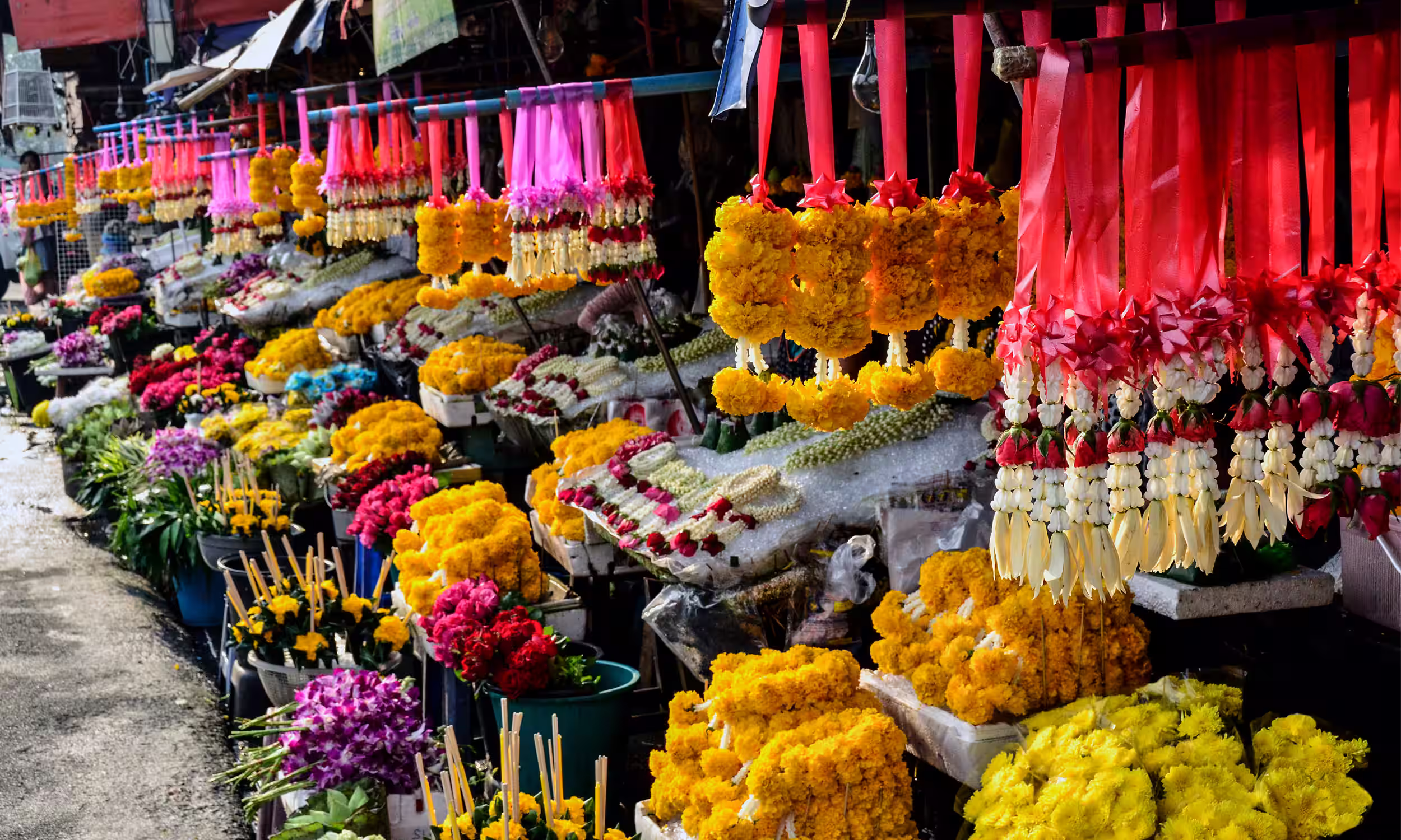 Mercado de flores em Chiang Mai com bancas coloridas e ambiente local.