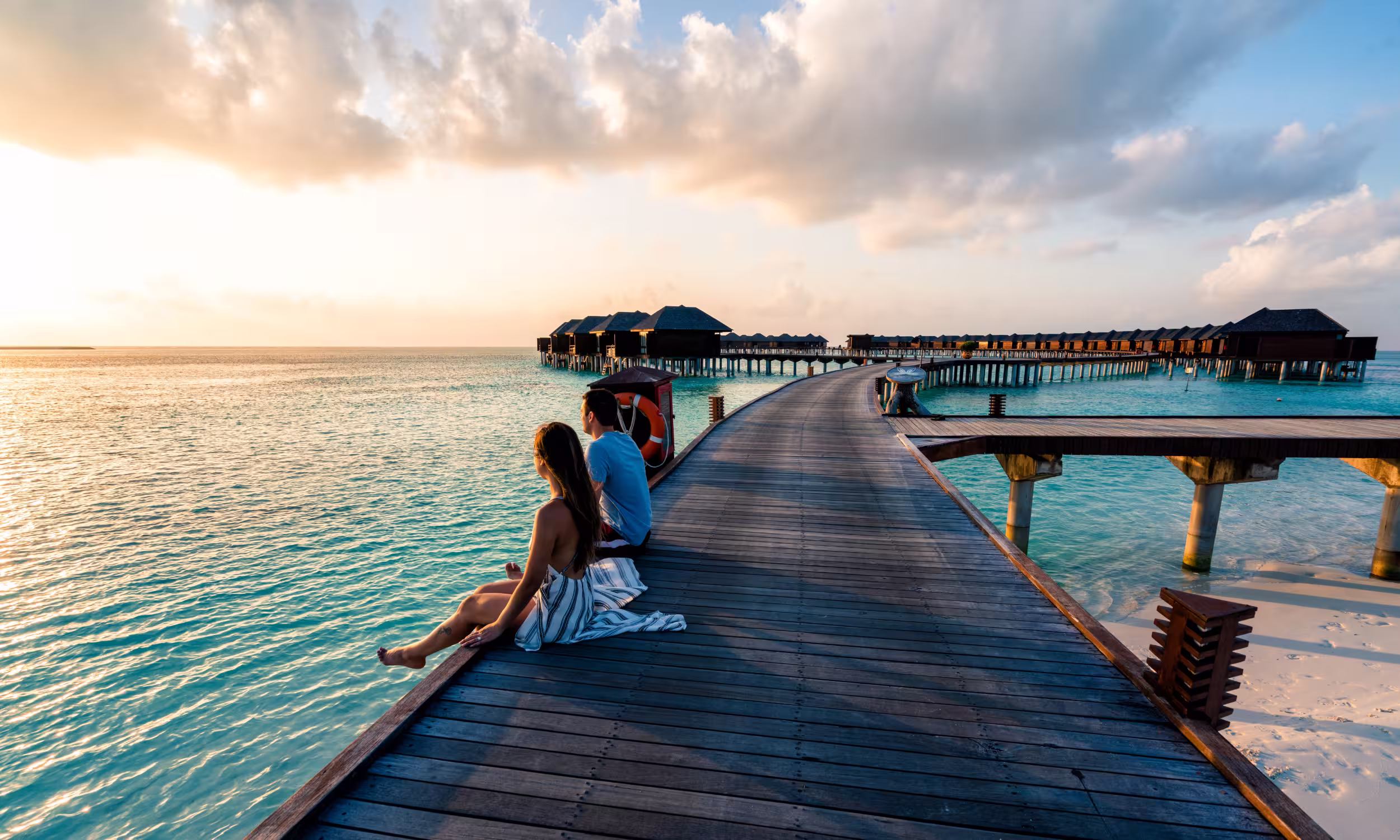 Couple enjoying a luxury honeymoon experience at an overwater villa resort.