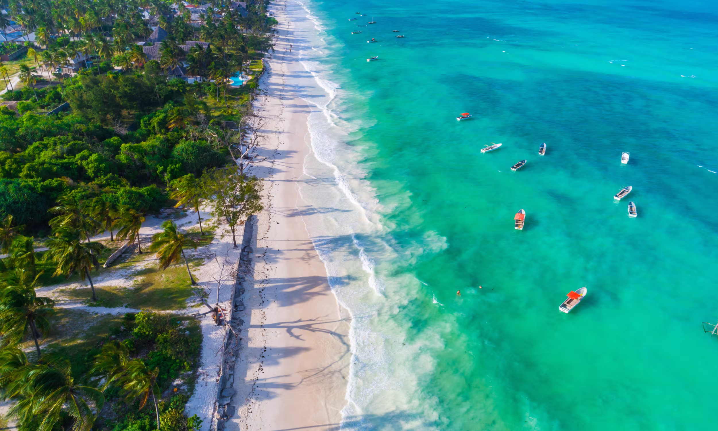 Vista aérea da costa de Zanzibar, destino tropical procurado para luas de mel premium.