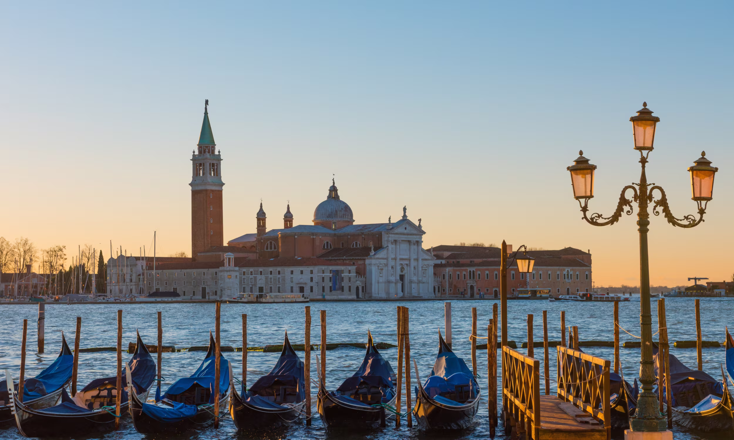 Couple enjoying a gondola ride through the canals of Venice on their honeymoon.